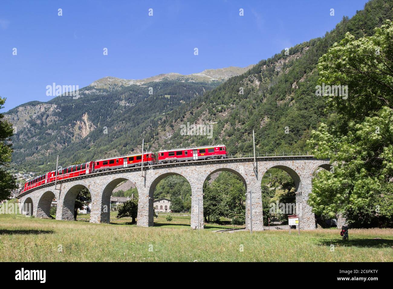 Brusio, Switzerland: 26 August 2018 - Bernina Express train is going through the famous circular viaduct in Swiss Alps mountain, Brusio, Canton Grison Stock Photo