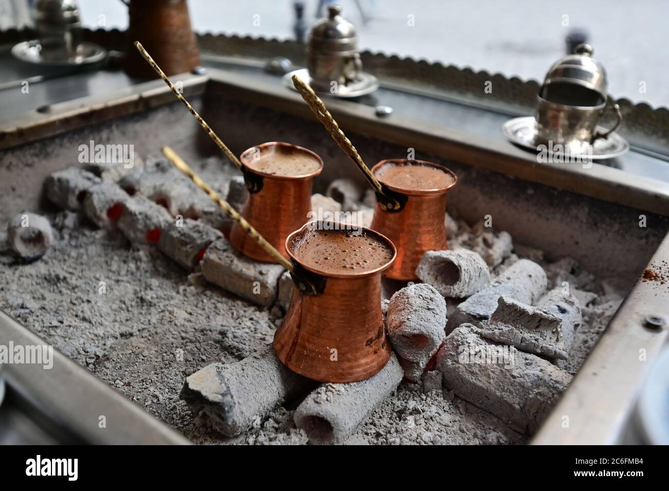 Traditional Turkish Coffee Brewing in Copper Pots over Hot Embers Stock Photo