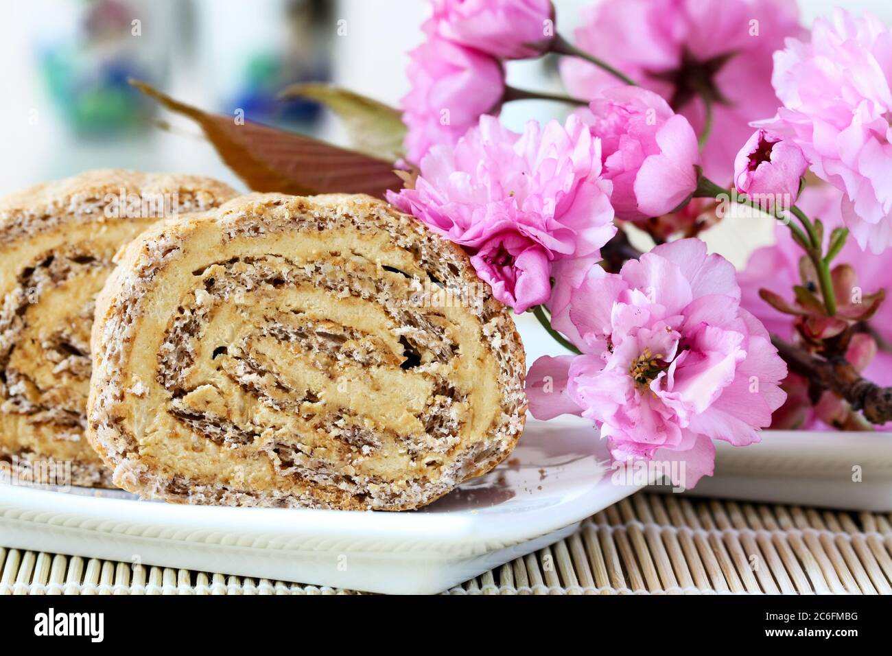 Japonais cake with cherry flower as decoration (a Japonaise cake is charecterised by layers of creamy coffee buttercream sandwiched between almond mer Stock Photo