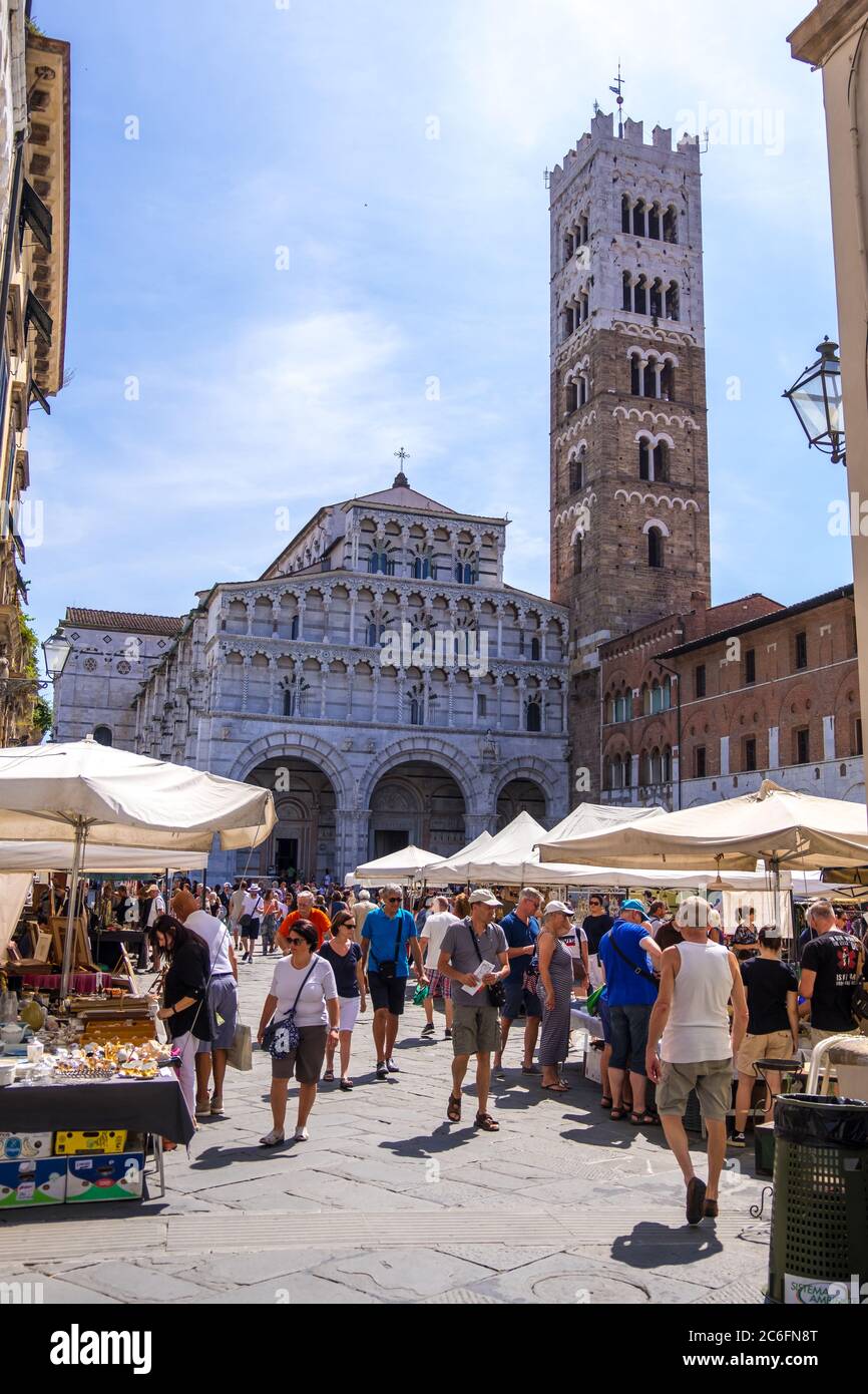 Lucca, Italy - August 17, 2019: A tourists and locals stroll on the Flea market in front of San Martino cathedral in historical centre of Lucca Stock Photo