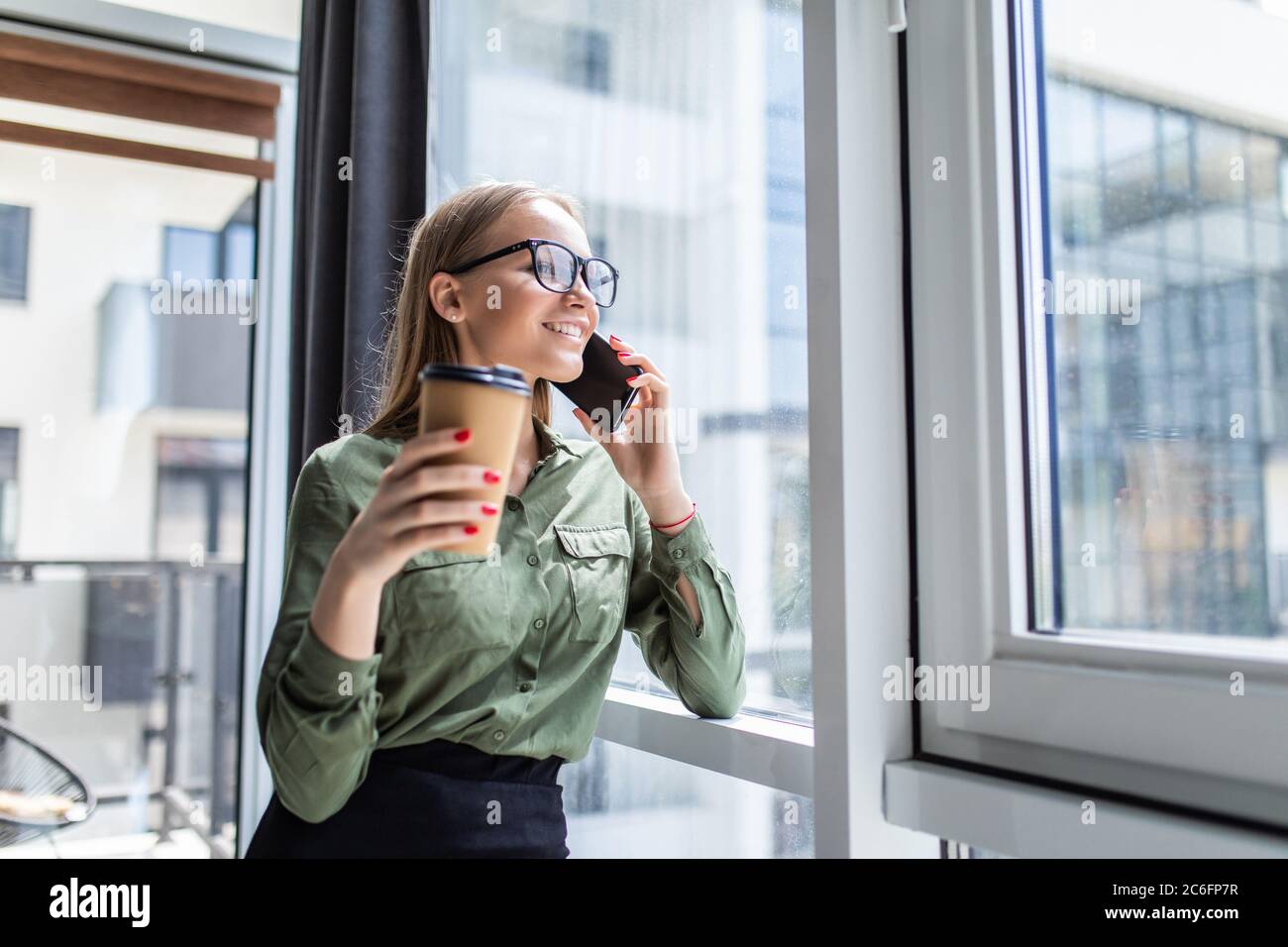 Young woman calling with cell telephone while sitting alone in coffee ...