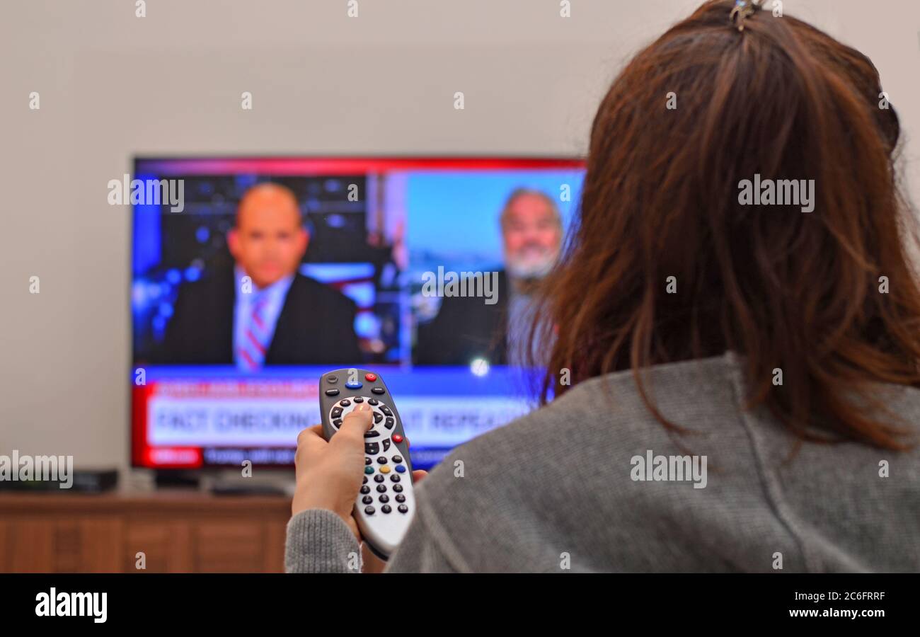 Women watching tv news and use remote controller Stock Photo