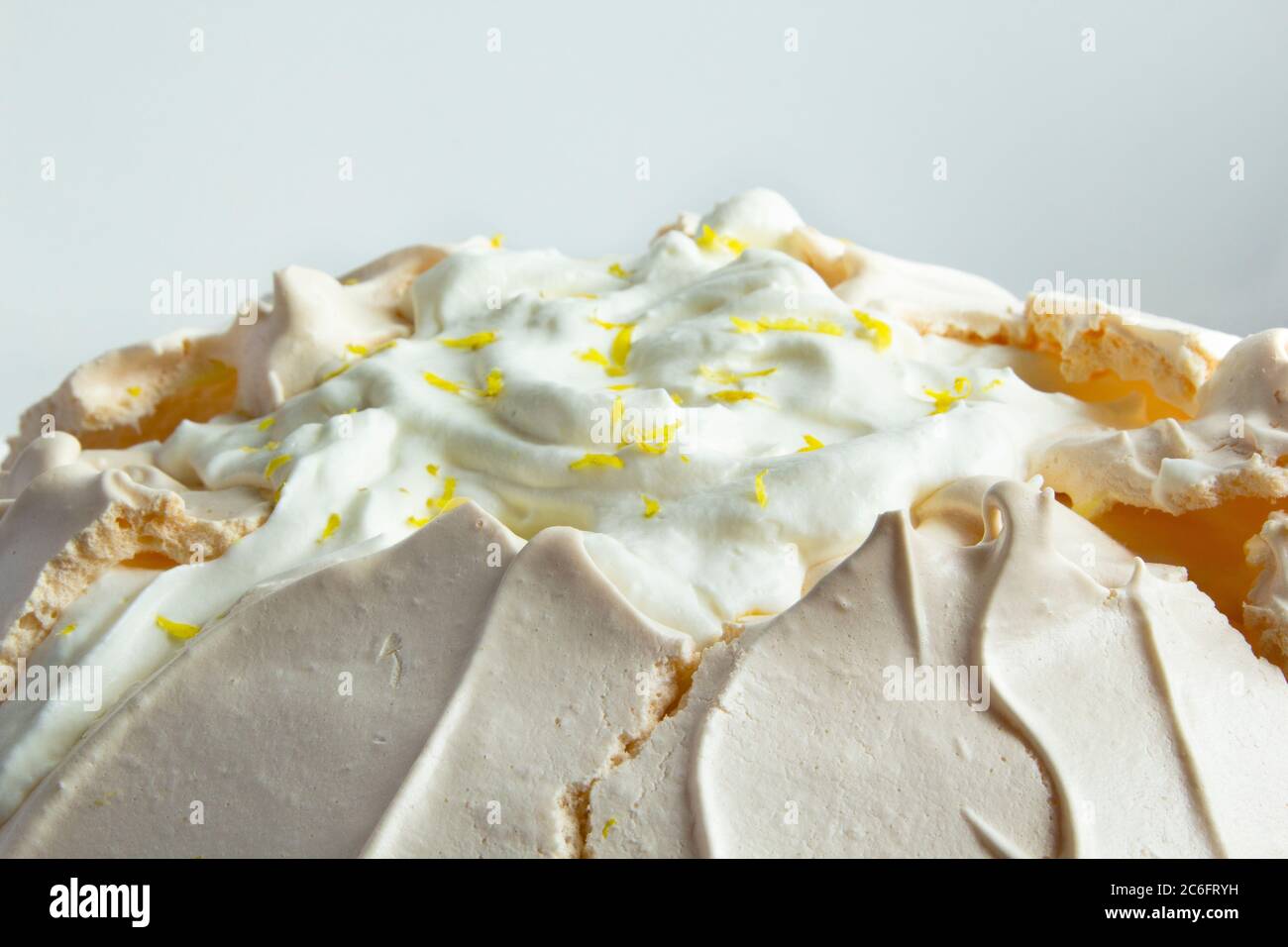 Homemade meringue cake Pavlova with whipped cream on glass cake stand ...
