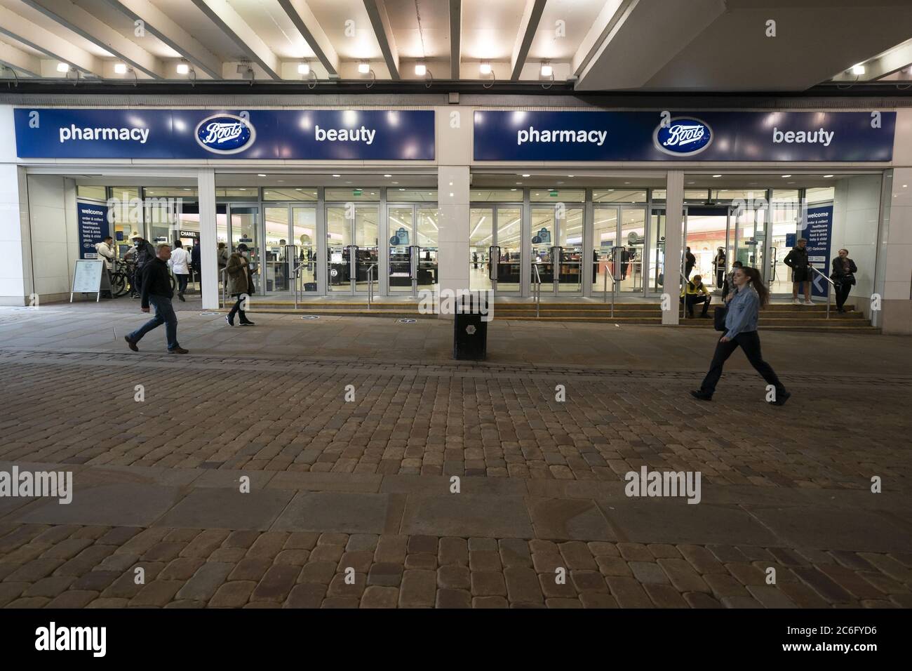 Manchester, Britain. 9th July, 2020. People walk past a Boots store in Manchester, Britain, on July 9, 2020. British high street pharmacy chain Boots announced Thursday that it will cut more than 4,000 jobs and close 48 opticians stores in an attempt to mitigate the significant impact caused by the COVID-19 pandemic. Credit: Jon Super/Xinhua/Alamy Live News Stock Photo