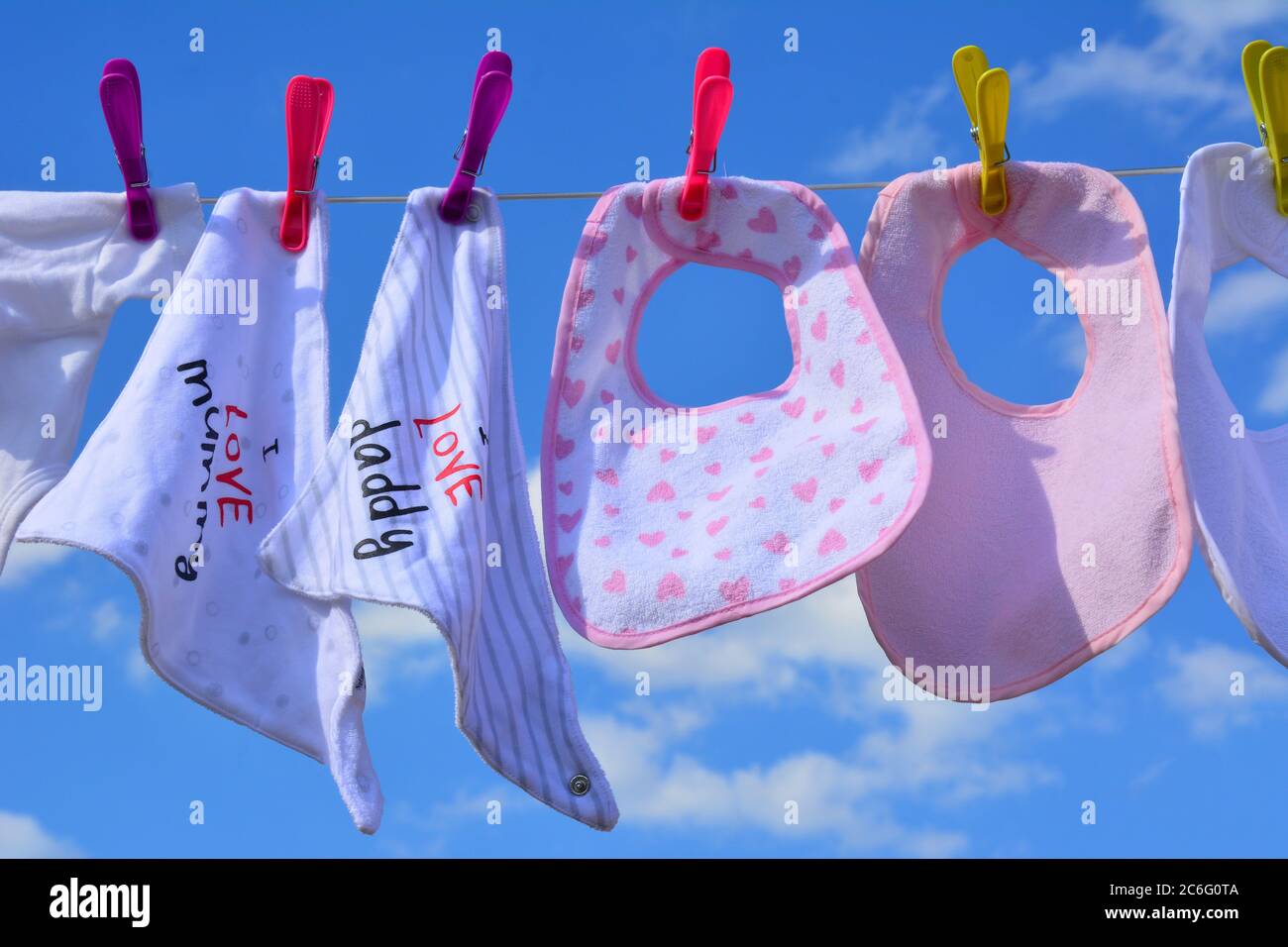 Baby bibs on a washing line on a sunny day Stock Photo
