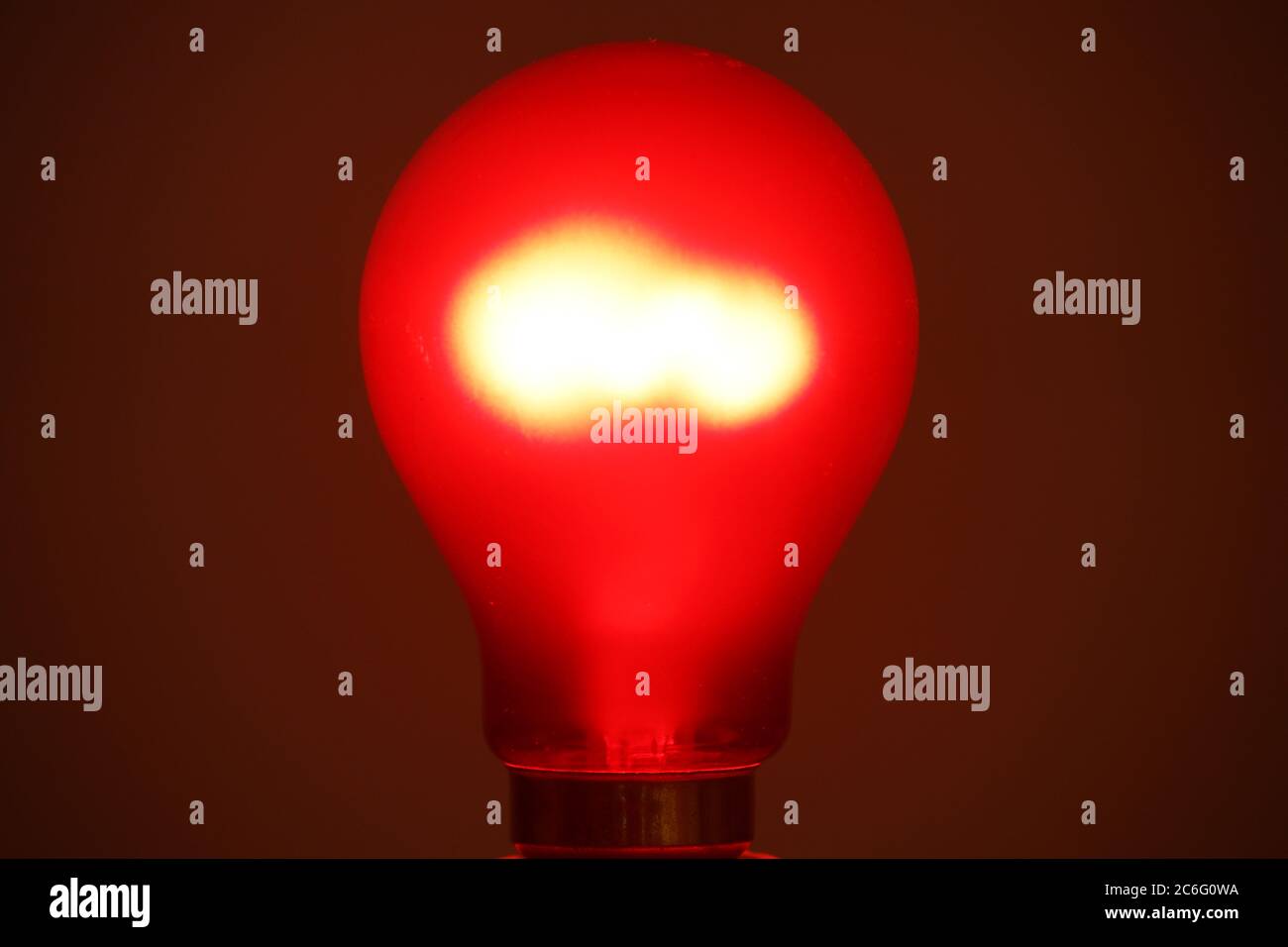 Crompton ruby red tungsten incandescent filament lightbulb lit, red