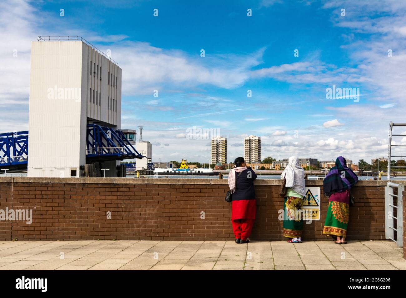 Women wearing shalwar kameez and dupatta, standing in front of the Woolwich Ferry terminal in London, UK Stock Photo