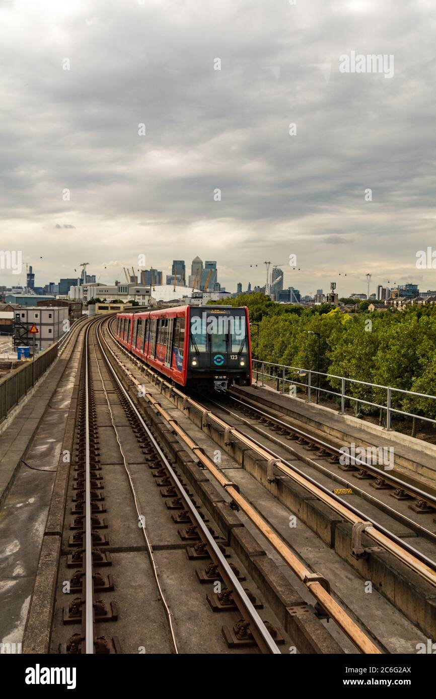 A Docklands Light Railway (DLR) train with the O2 Arena and Canary Wharf in the background, London, UK. Stock Photo