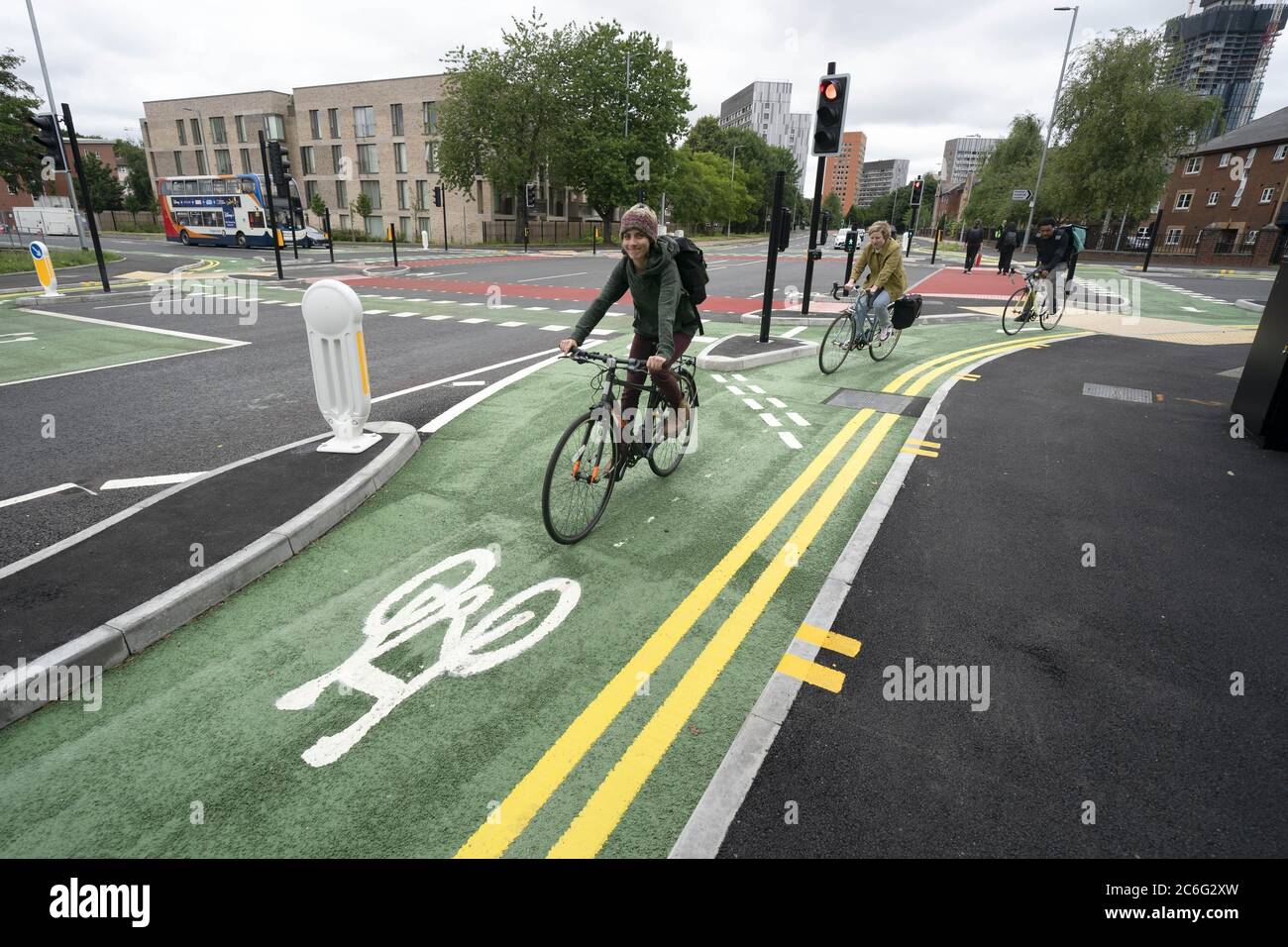 Manchester, Britain. 9th July, 2020. People ride bicycles on the cycle lane of a CYCLOPS (Cycle Optimised Protected Signals) junction in southern Manchester, Britain, on July 9, 2020. The CYCLOPS junction has been launched in Manchester. The unique design separates pedestrians and cyclists from traffic, reducing the possibility of collisions or conflict. Credit: Jon Super/Xinhua/Alamy Live News Stock Photo