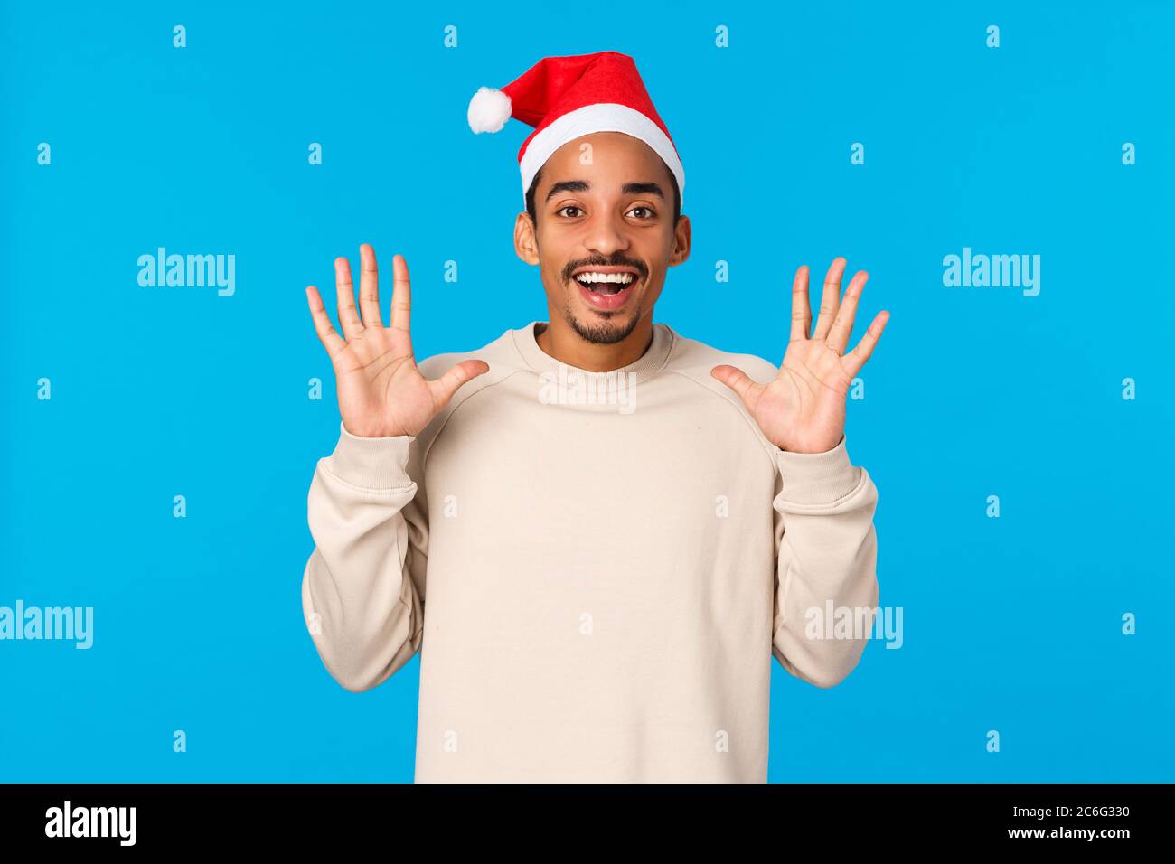 Man catching presents in santas hat. Cheerful african-american young ...