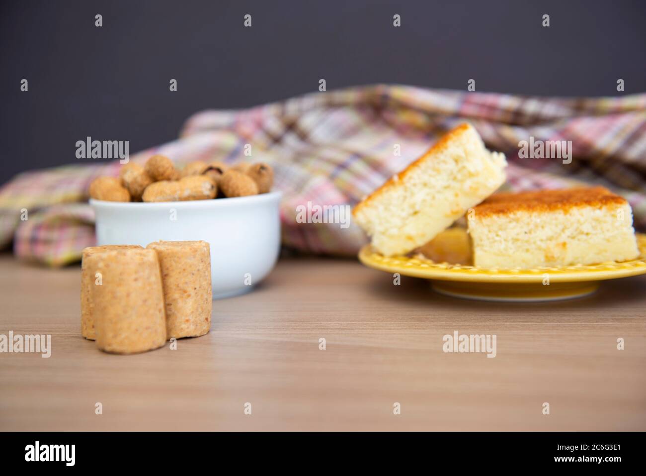 Typical June Party foods on a wooden table: cornmeal cake, peanut pods, peanuts candy (paçoca) and dulce de leche. Copy space. Selective Focus. Stock Photo