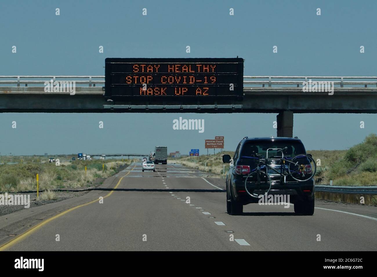 Street signs on the highway show awareness and warnings for the pandemic COVID-19. Stock Photo