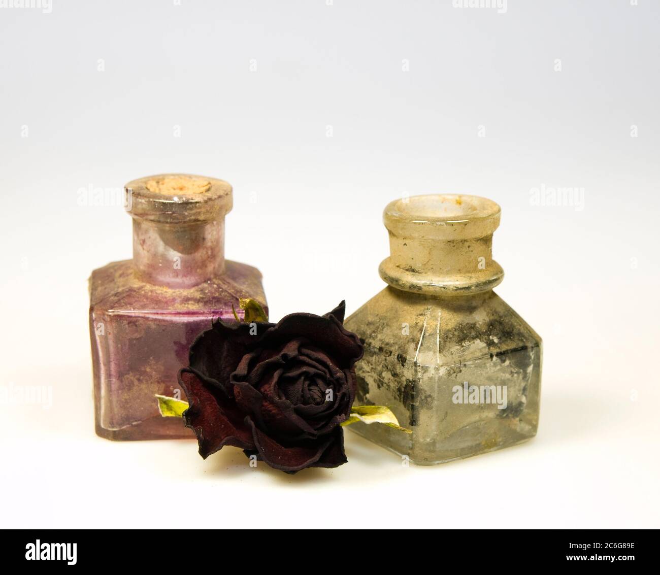 Odl styled dirty glass bottles with dry rose flower Stock Photo