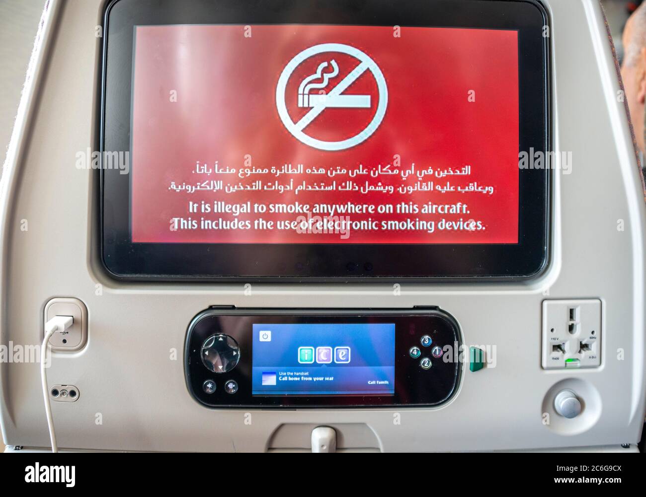 Screen with display smoking ban in Arabic and English on backrest in aircraft, Emirates airline, interior, Dubai, United Arab Emirates Stock Photo