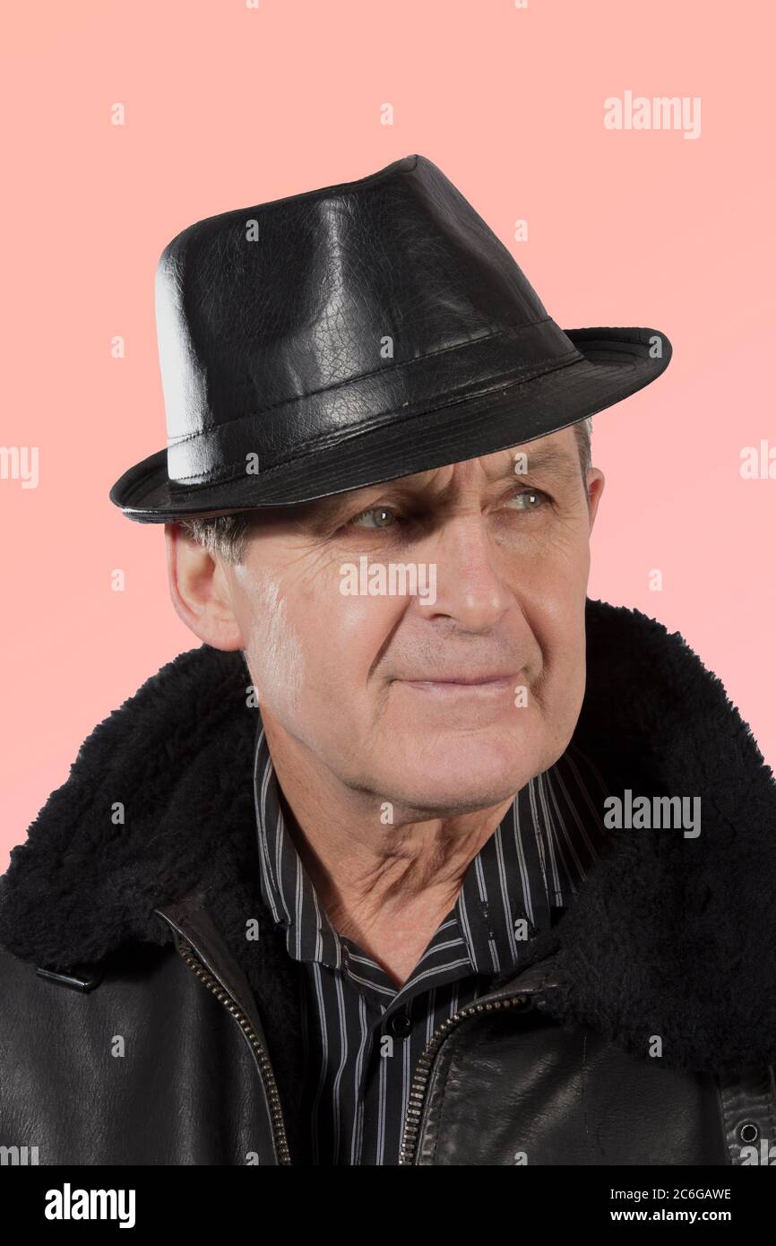 Older man wearing leather hat, jacket Stock Photo