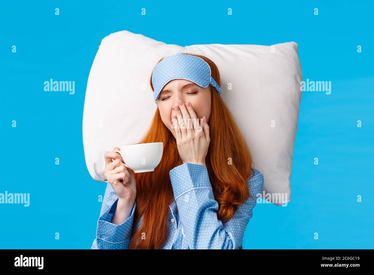 Sleepy cute redhead european girl with long ginger hair, wearing