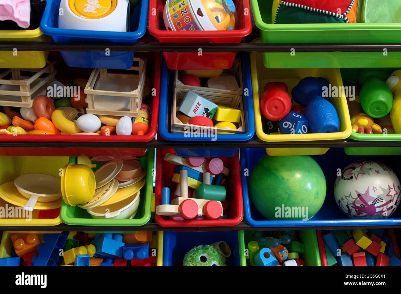 Many children's toys separated and organized in colorful bins. Stock Photo