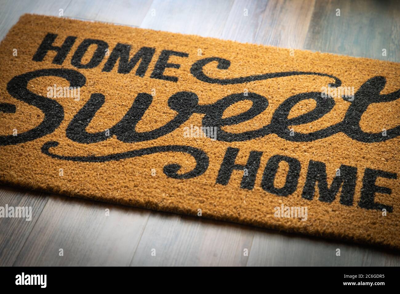 Home Sweet Home Welcome Mat Resting on Floor. Stock Photo