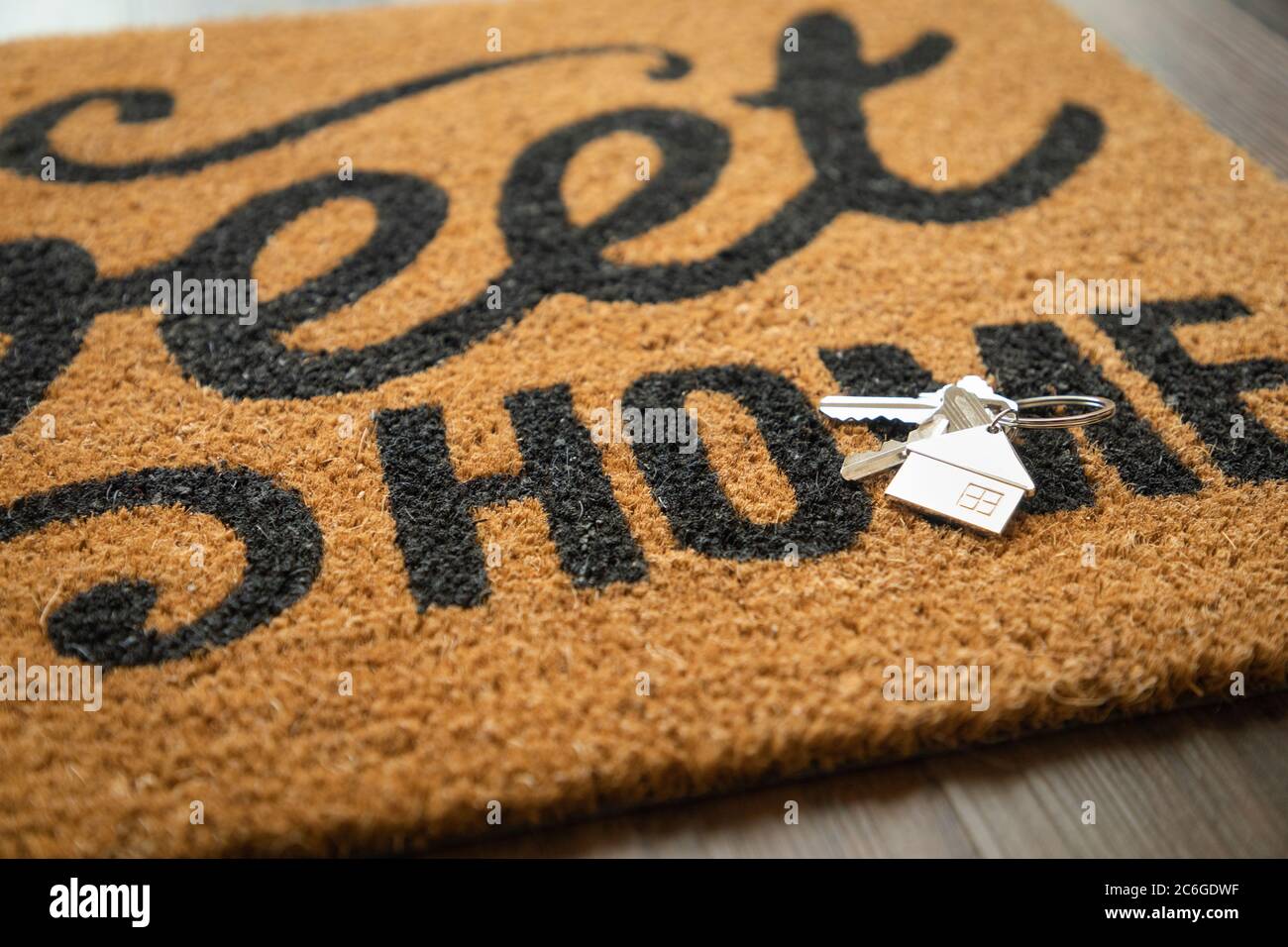 New House Keys and Keychain Rests on Home Sweet Home Welcome Mat. Stock Photo