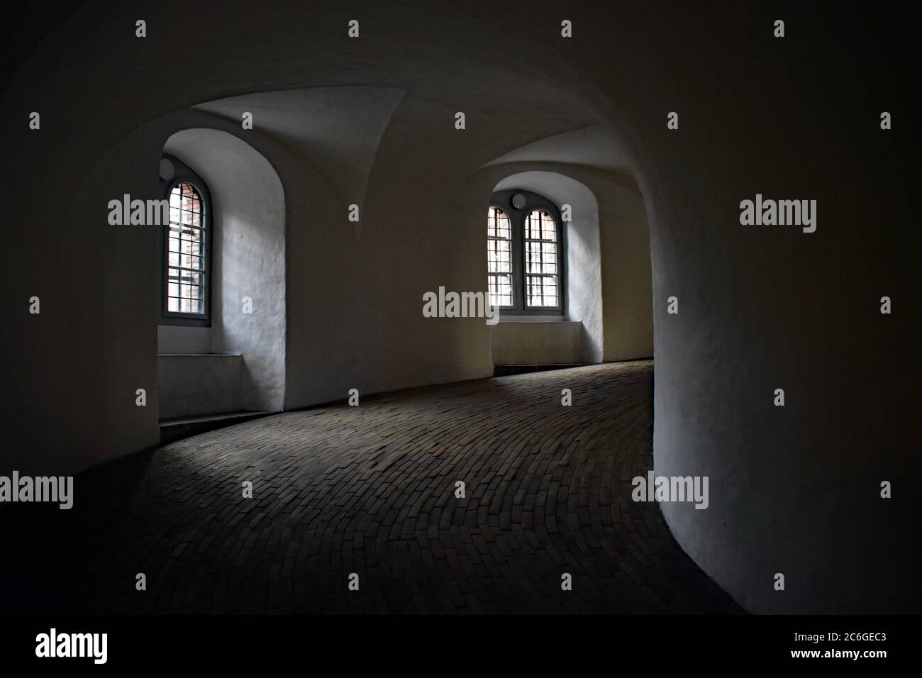 The smooth flat spiral ramp on the inside of the Round Tower in Copenhagen.  An equestrian staircase so horses could ascend.  Two windows let light in. Stock Photo
