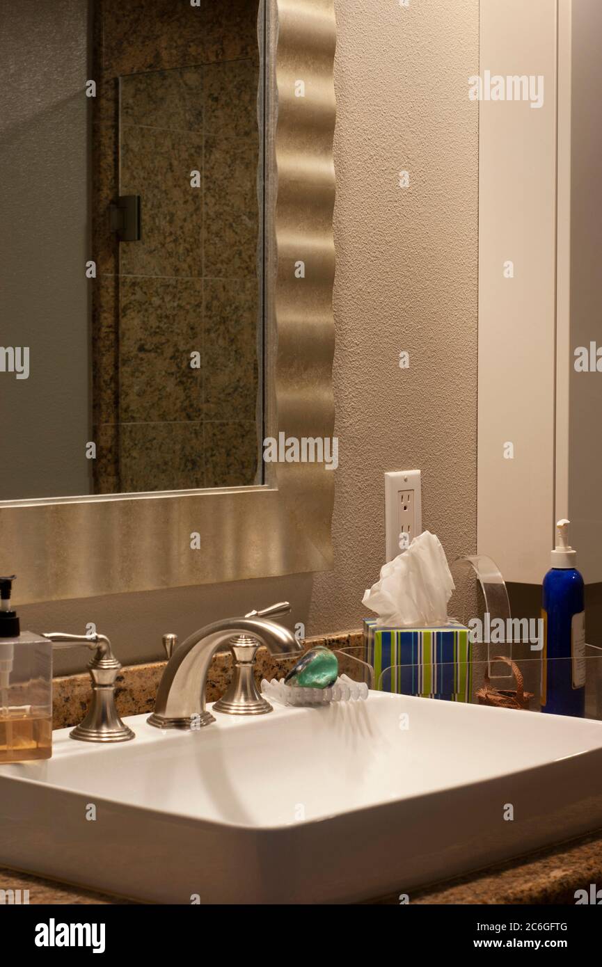 Bathroom sink and mirror closeup with text message space in mirror frame. Contemporary square sink builtin with granite surrounds. Stock Photo