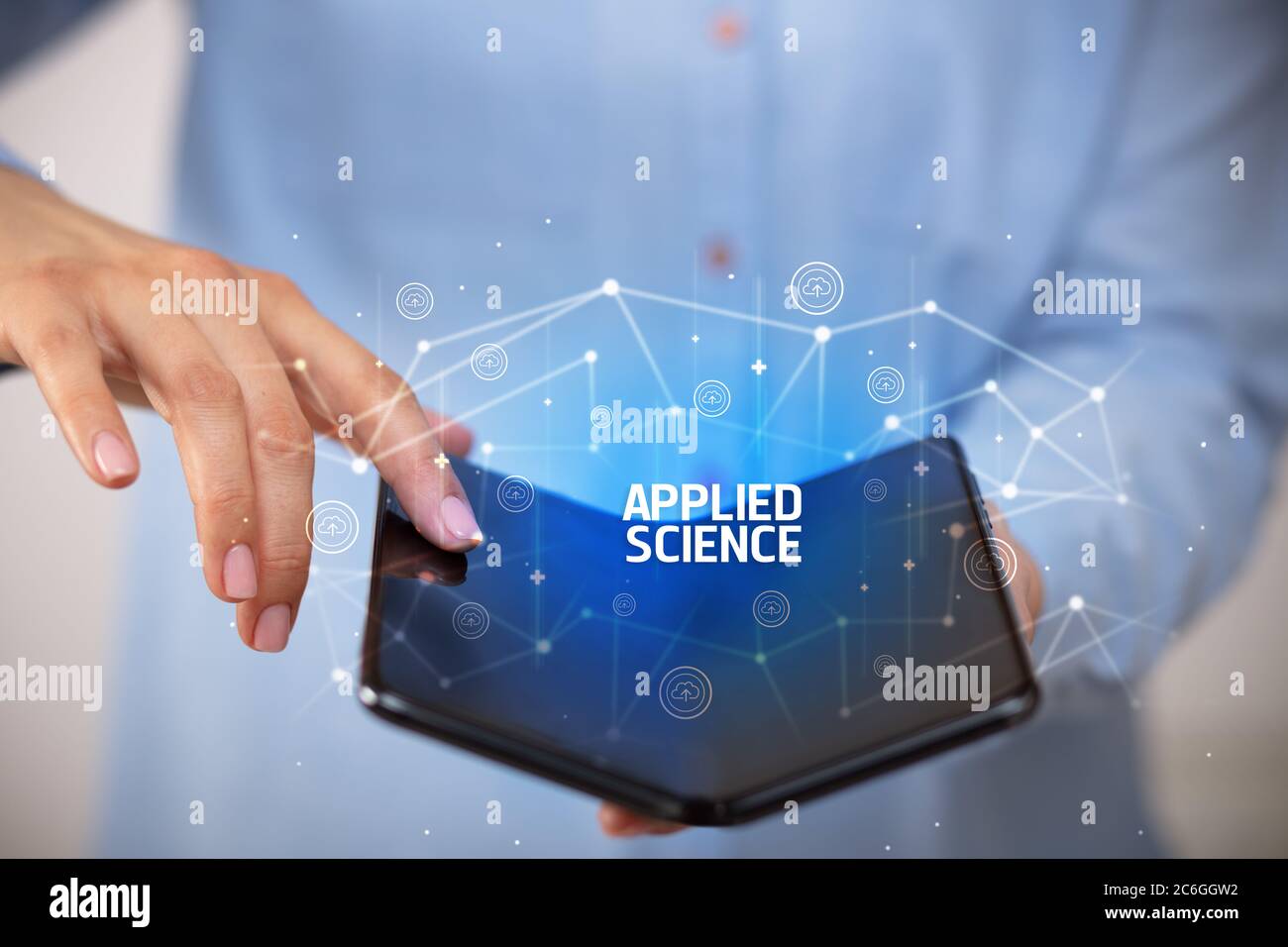 Businessman holding a foldable smartphone with APPLIED SCIENCE inscription, new technology concept Stock Photo
