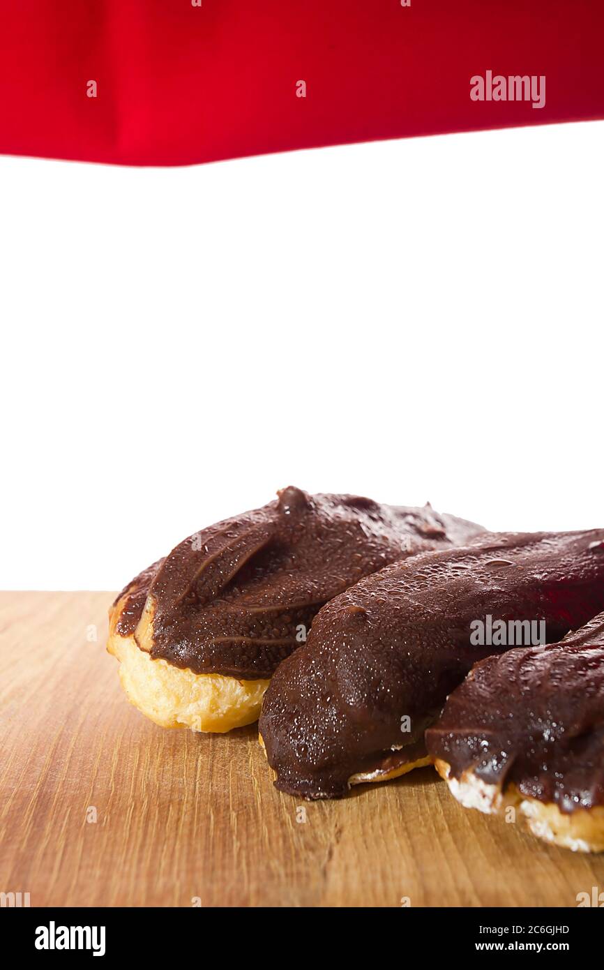 Eclairs with chocolate icing on a wooden table Stock Photo