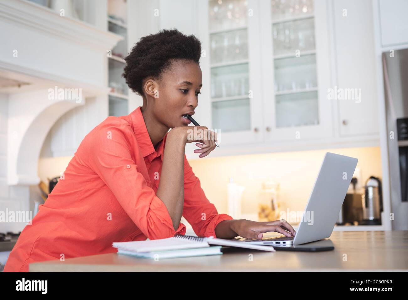 Woman using laptop in the kitchen Stock Photo
