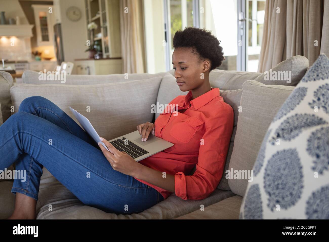 Woman using laptop while sitting on the couch Stock Photo