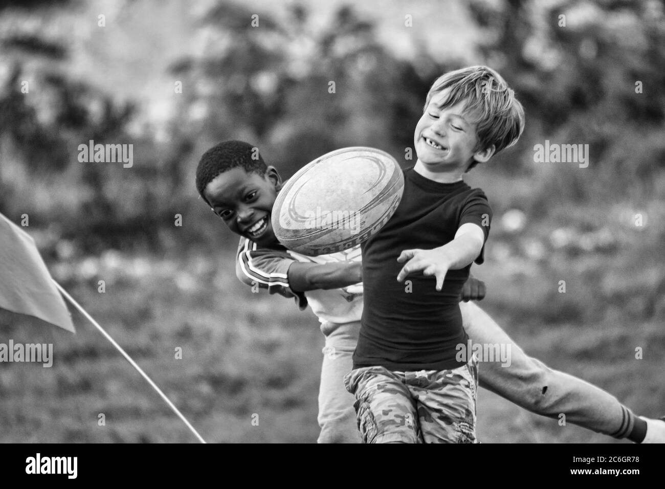 Black little boy playing happily with White little boy. Showing racial harmony. That black and white races can exist happily together Stock Photo