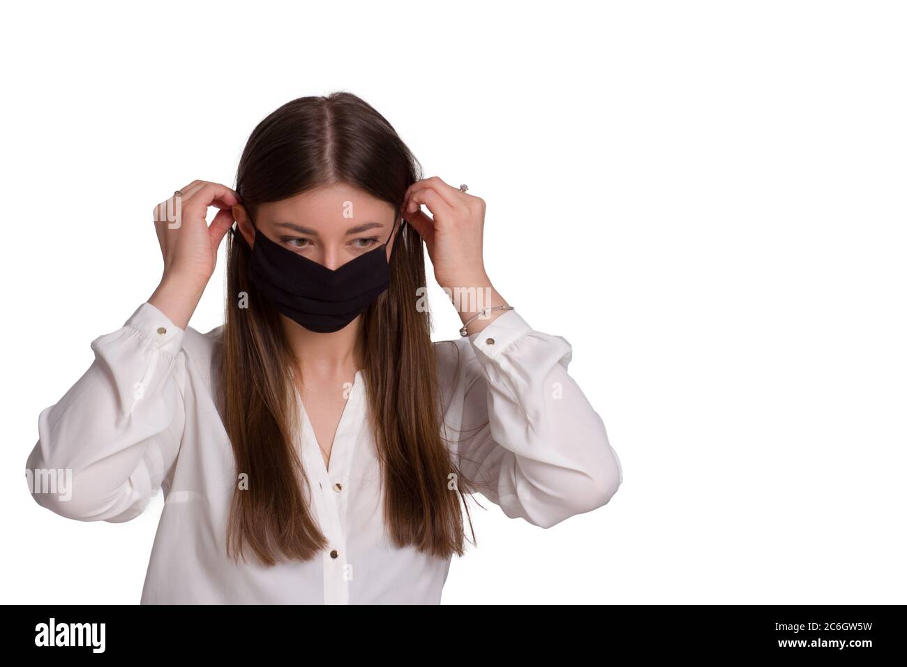 A young woman wears a black protective mask. Isolated on white. The concept of a viral epidemic. avoiding covid-19 . Stock Photo
