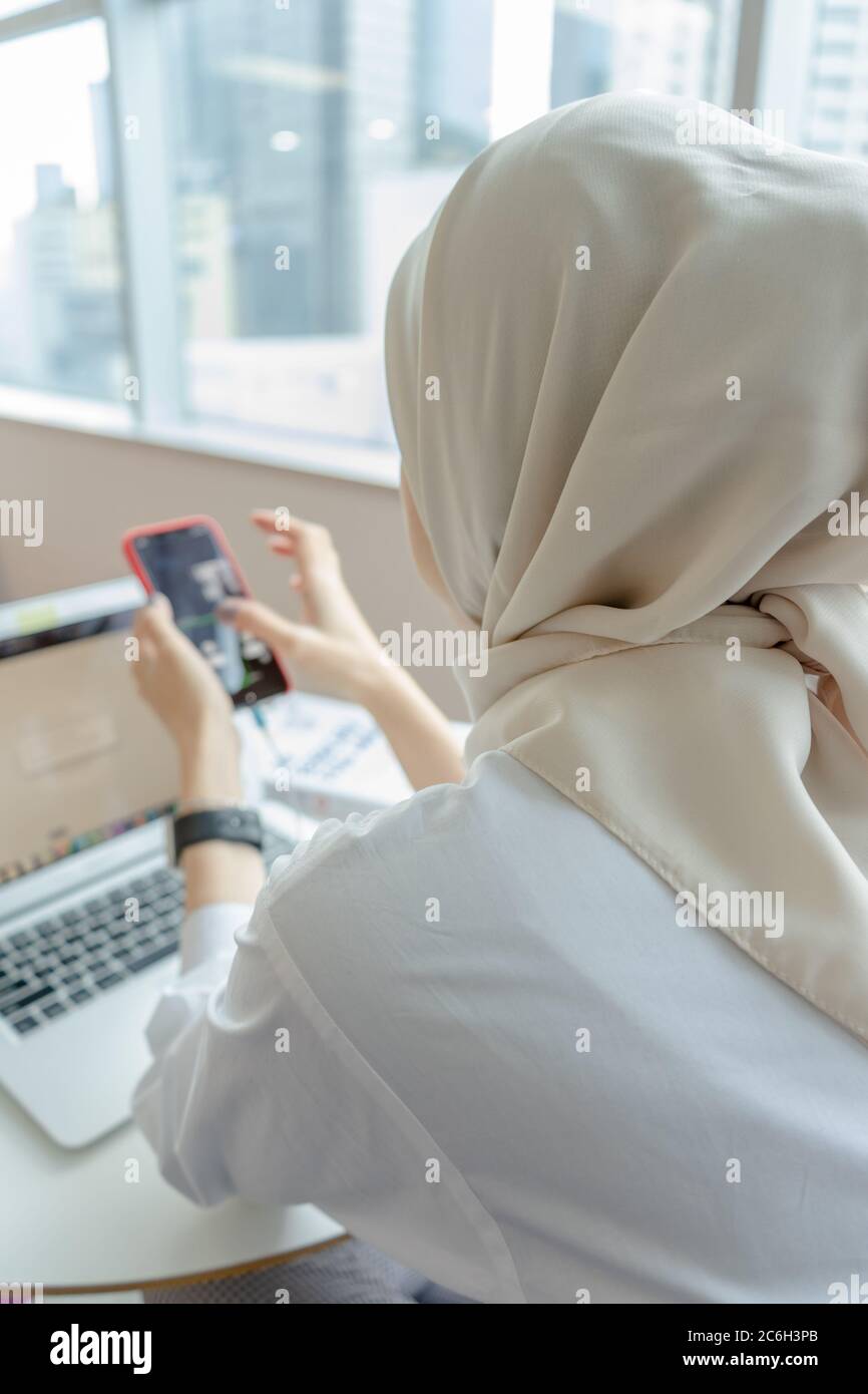 muslim women doing work with her gadget Stock Photo