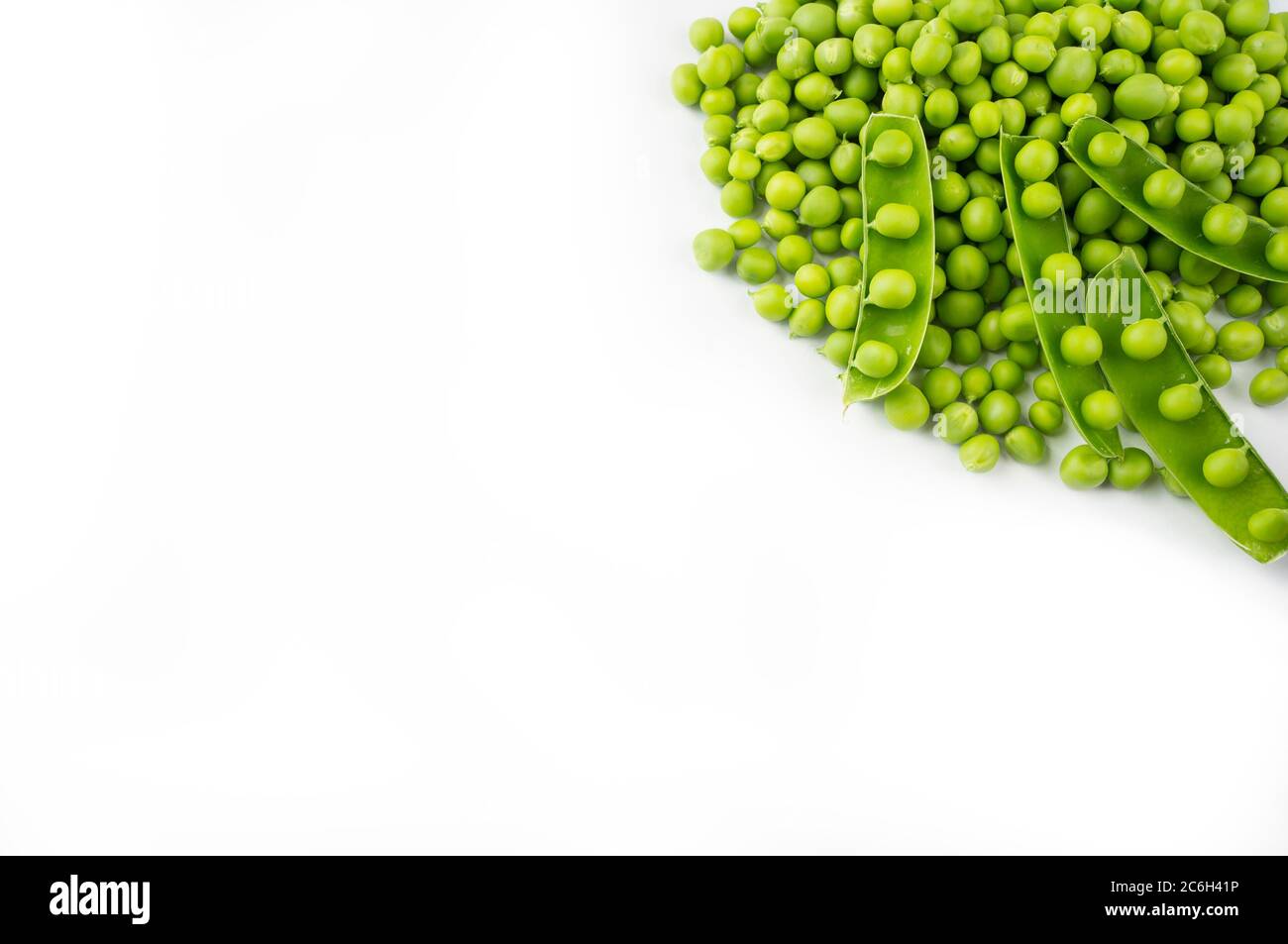 Green peas on a white background. Green peas at border of image with copy space for text. Fresh green peas on a white background. Stock Photo