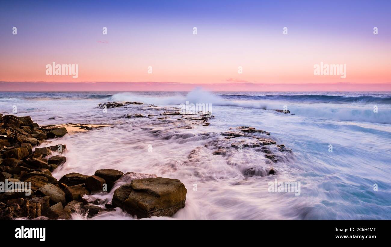 Strong sea wave crashing rocky coastline in Royal National Park Stock Photo