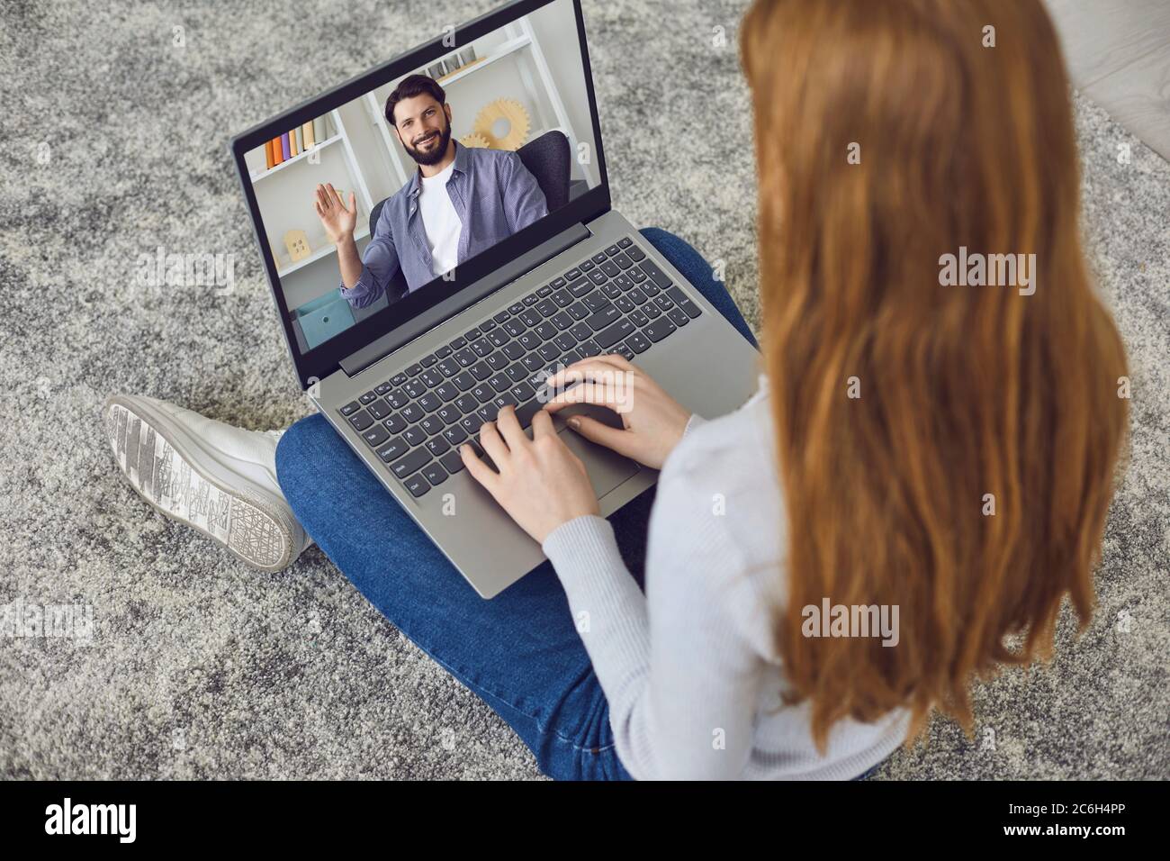 Online chat. The girl has a video call laptop with a man sitting at home. Stock Photo