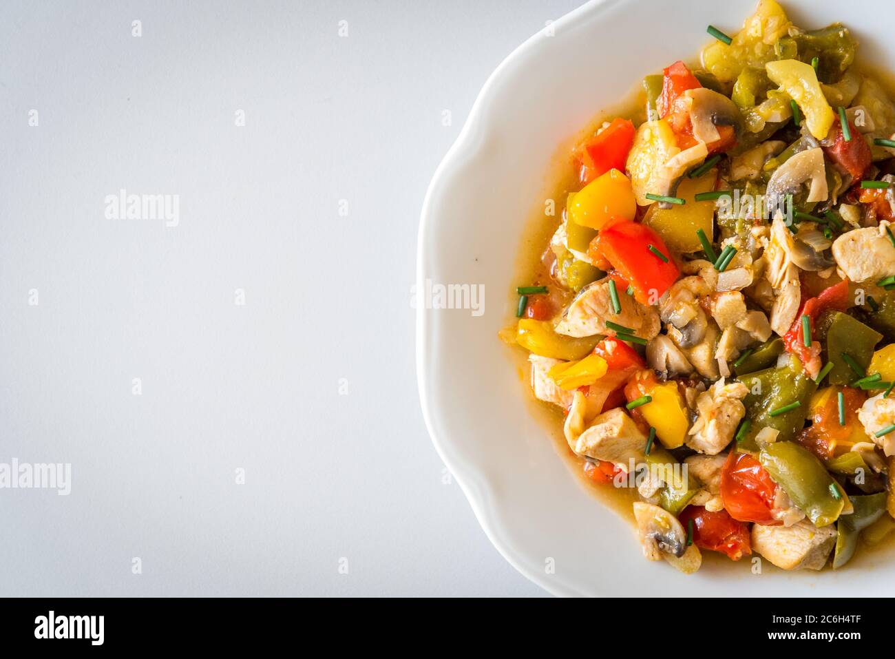 Chicken curry nuggets with grilled vegetables on a white plate. Space in left side Stock Photo