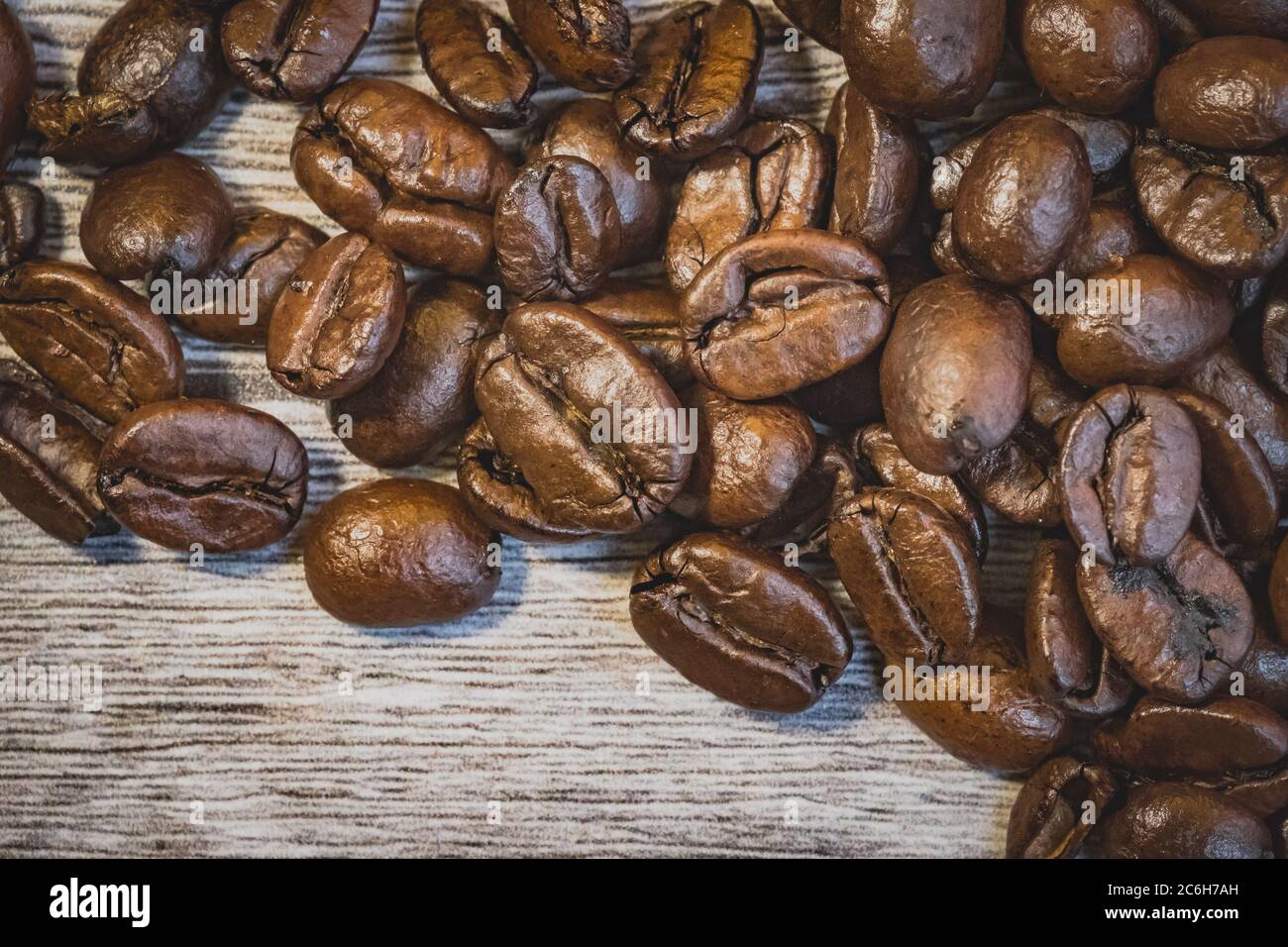 Macro view of freshly roasted coffee beans seen on a wooden table ...
