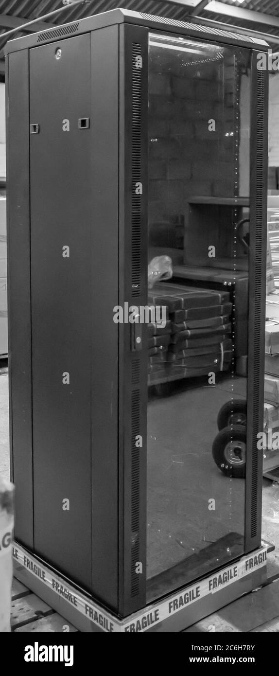 Detailed image of a Computer and Network server cabinet showing the front meshed door open. Stock Photo