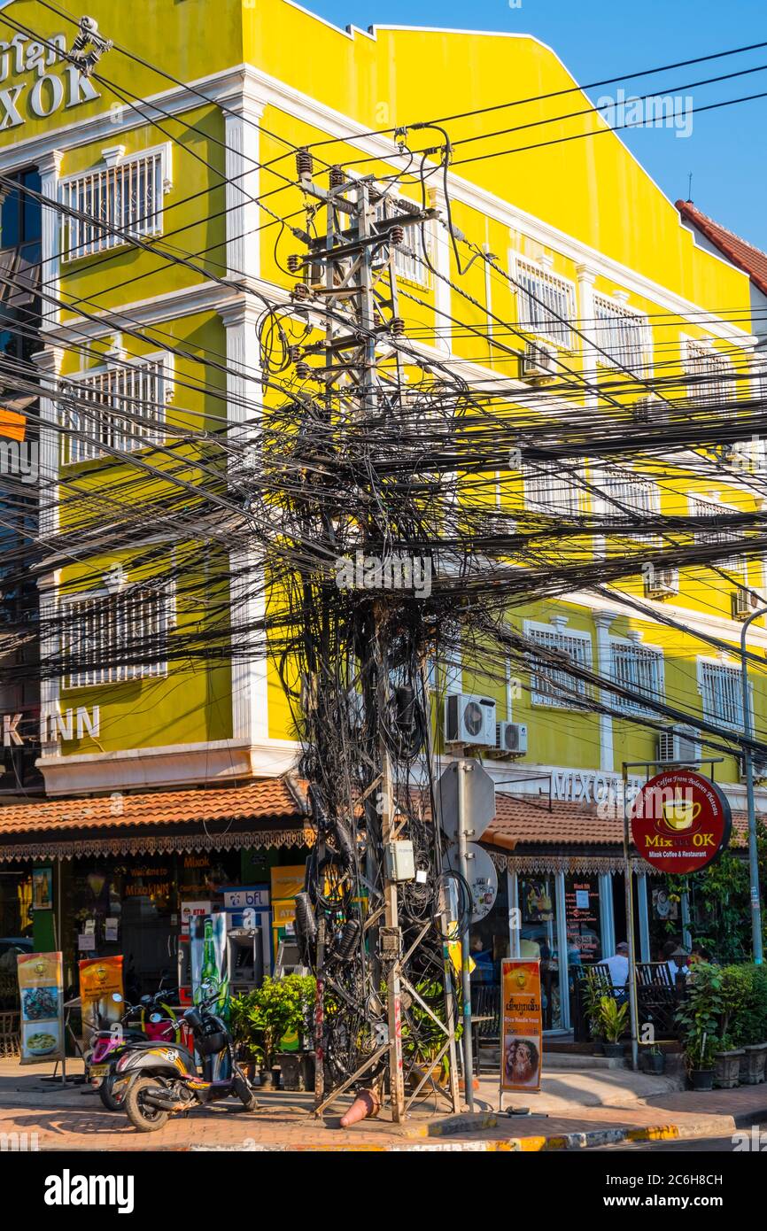 Electricity pylon, full of telephone and electricity cables, Rue Samsenthai, Vientiane, Laos Stock Photo