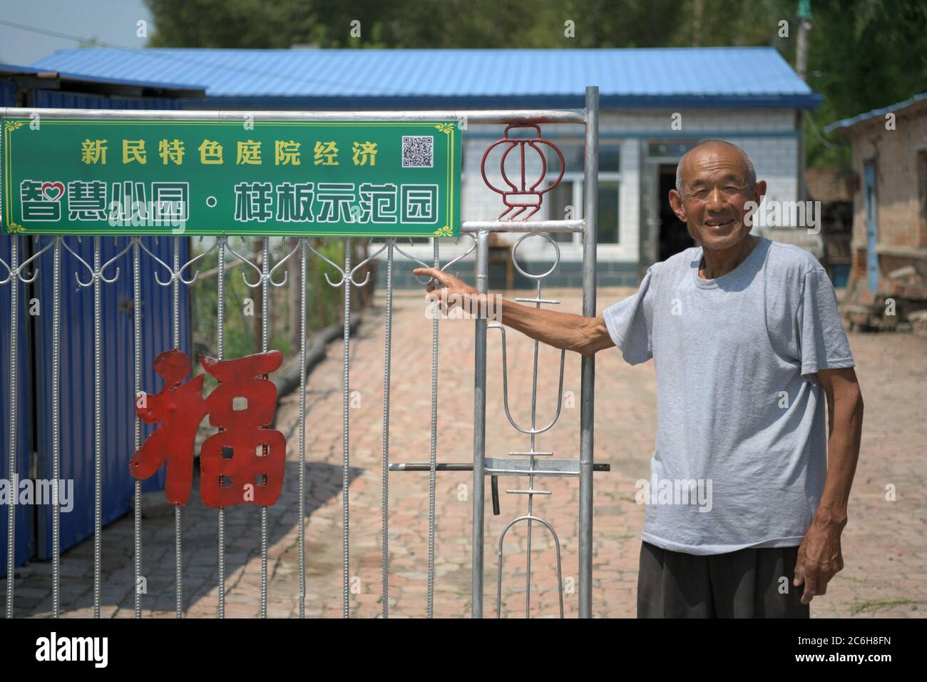 (200710) -- LINDIAN, July 10, 2020 (Xinhua) -- Tang Zhanjun, a villager whose household has shaken off poverty, introduces his home yard in Xinmin Village of Lindian County, northeast China's Heilongjiang Province, July 9, 2020.  Local authorities of Lindian have guided local villagers to plant vegetables at their own house yards and help them expand distribution channels, as a way to help them increase incomes and shake off poverty. A total of 14,000 households, including 3,000 poverty-stricken households, have engaged in home yards planting. (Xinhua/Wang Jianwei) Stock Photo