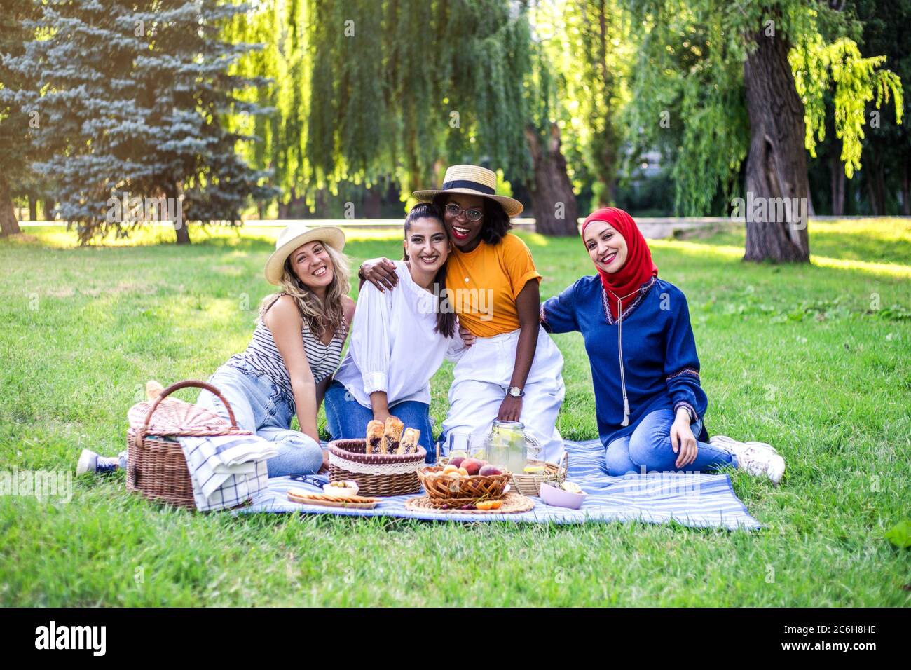 Young multiracial women are on picnic in the park. Stock Photo