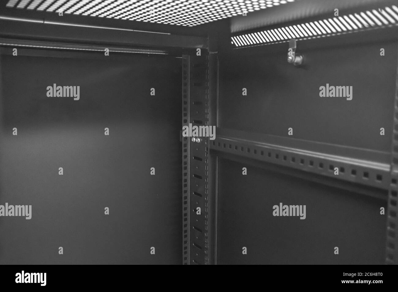 Detailed image of a Computer and Network server cabinet showing the front meshed door open, seen in a data centre for hosting servers. Stock Photo