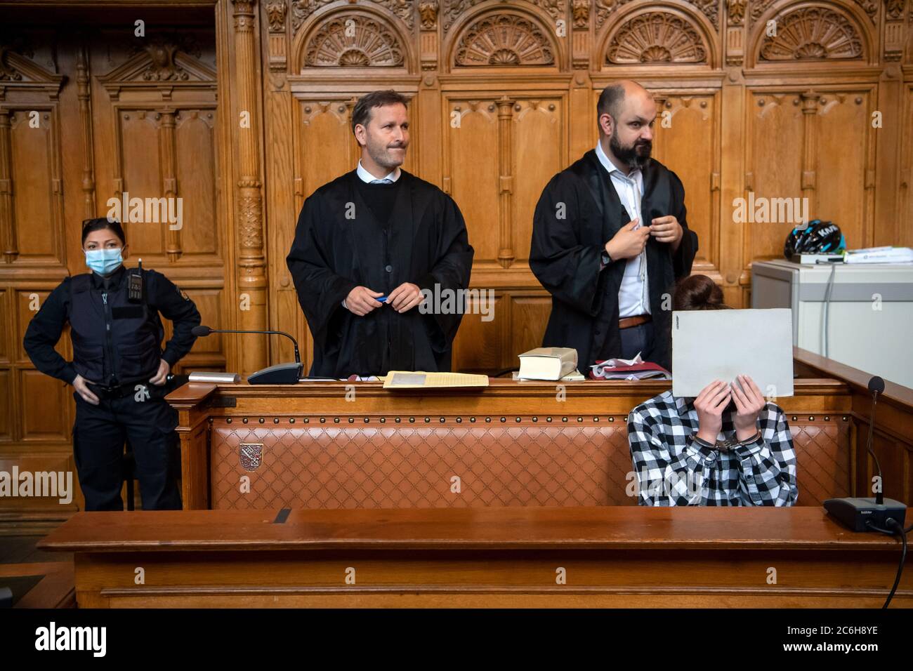 Bremen, Germany. 10th July, 2020. The defendant in the murder trial sits in the courtroom with her lawyers Mario Kroschewski (r) and Stefan Hoffmann (M) before the trial begins. The public prosecutor accuses the 20-year-old woman of having used a sharp object to make deep and wide cuts to her 24-year-old boyfriend. The man bled to death. Credit: Sina Schuldt/dpa/Alamy Live News Stock Photo