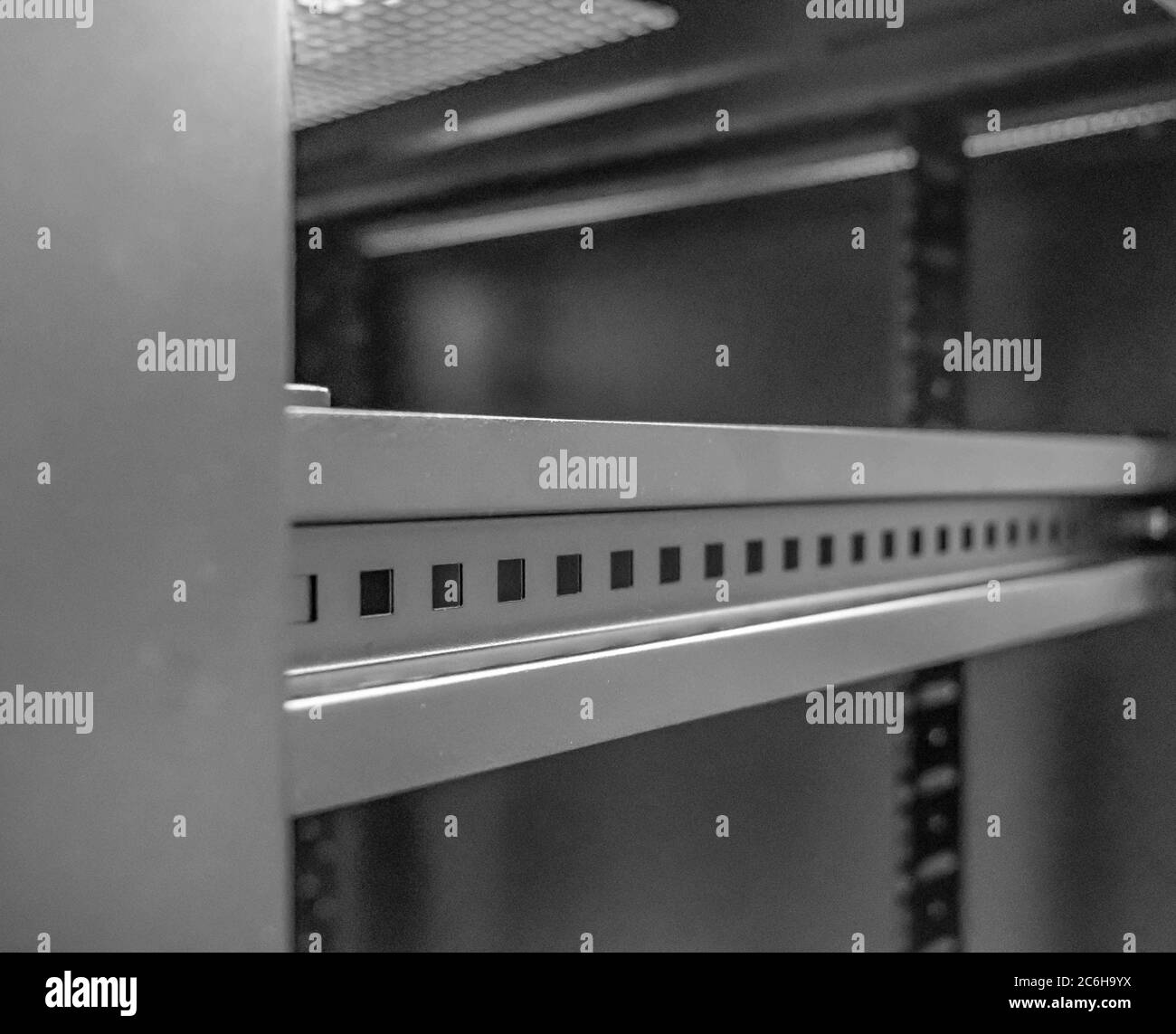 Detail of the 19-inch mounting posts together with cable entry plates seen on the base of the cabinet. The equipment rack is used to house IT servers. Stock Photo