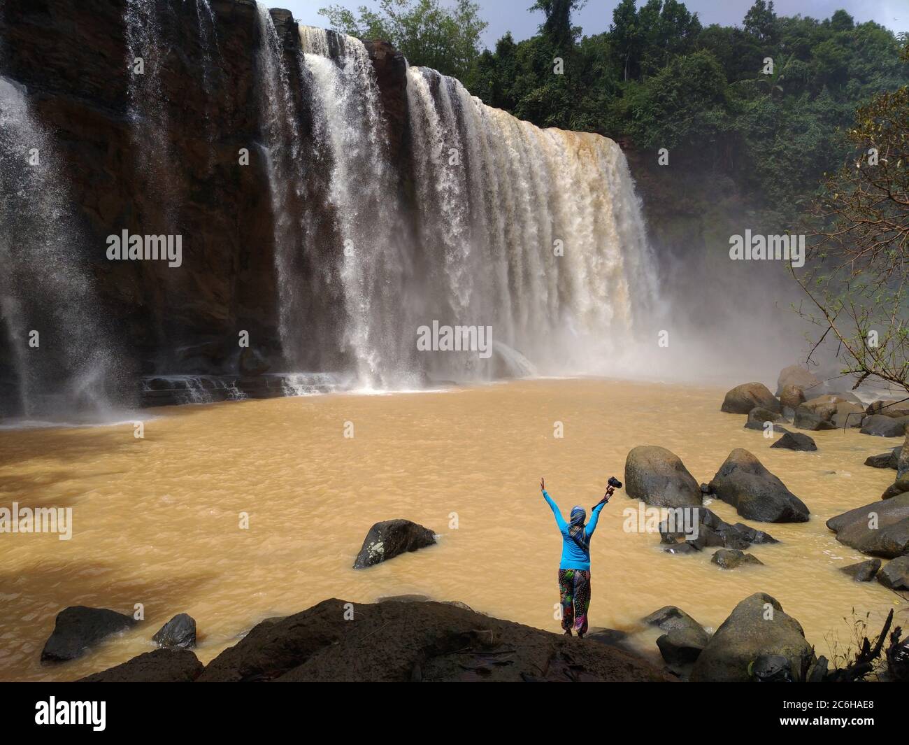 a person enjoying a view of Awang Waterfall, Ciletuh Geopark area, West Java , Indonesia Stock Photo