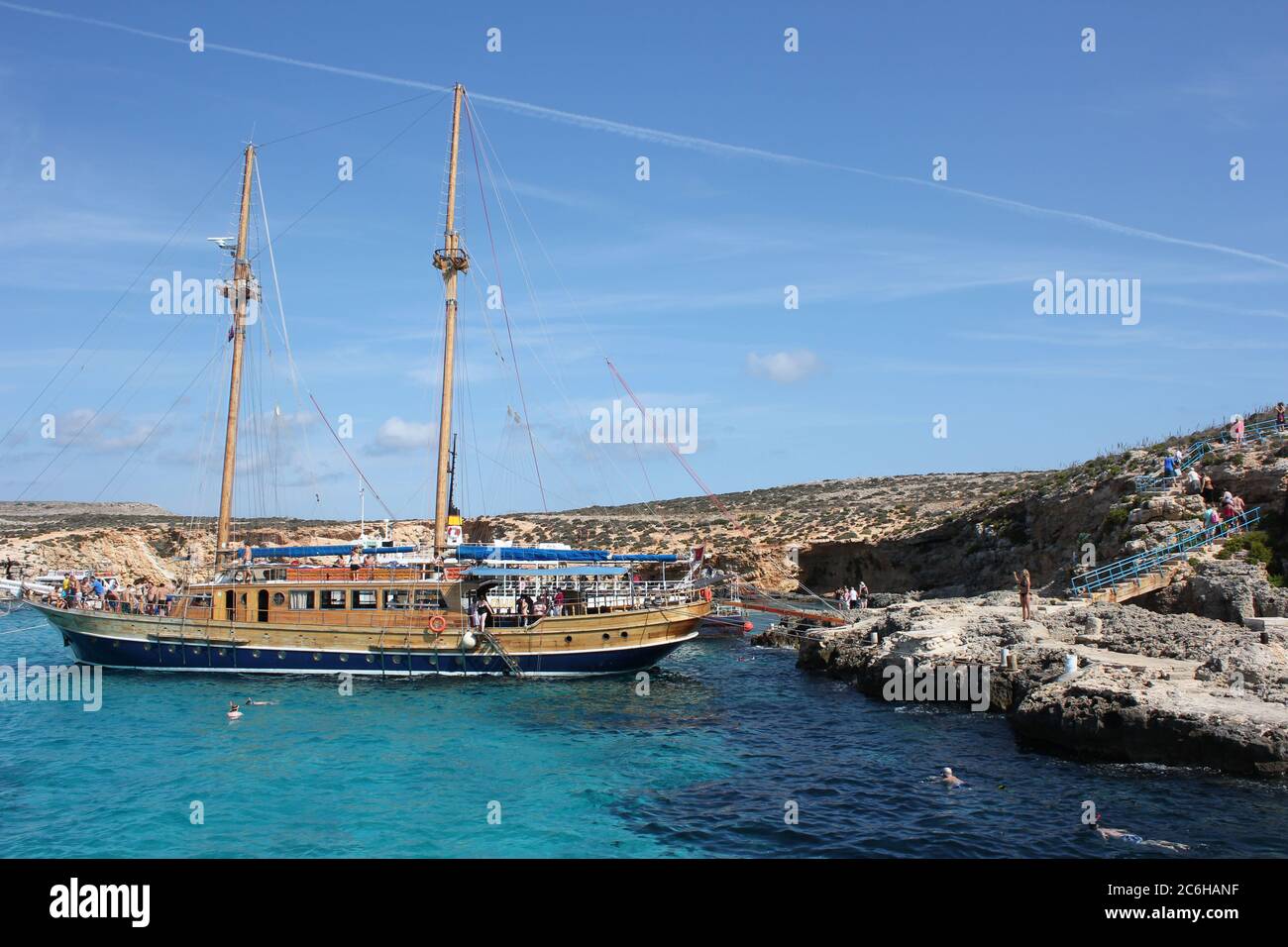 Tourist vessel anchored in the clear waters of the Blue Lagoon at Comino Island, Malta Stock Photo