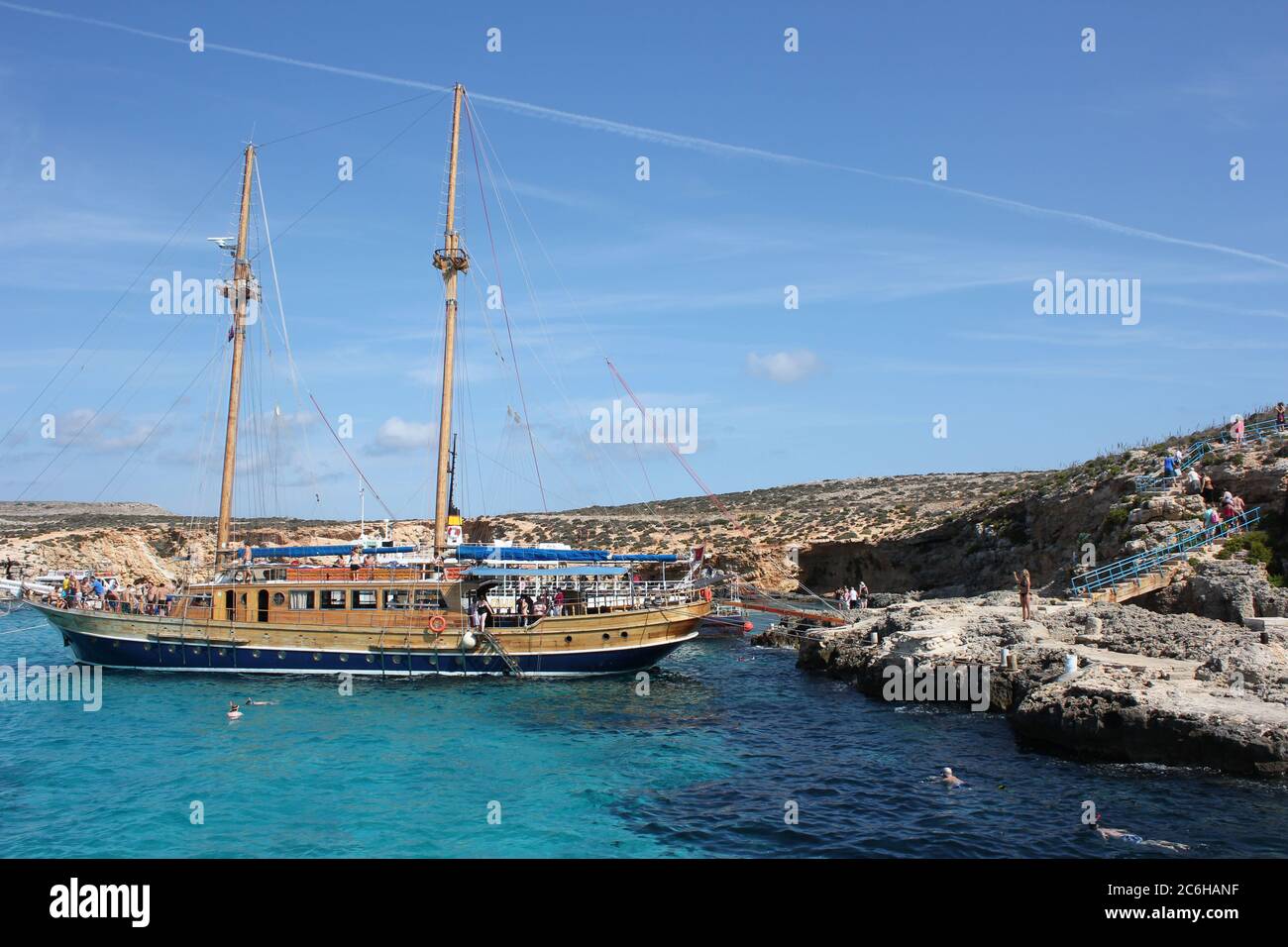 Tourist vessel anchored in the cynic waters of the Blue Lagoon at Comino Island, Malta Stock Photo