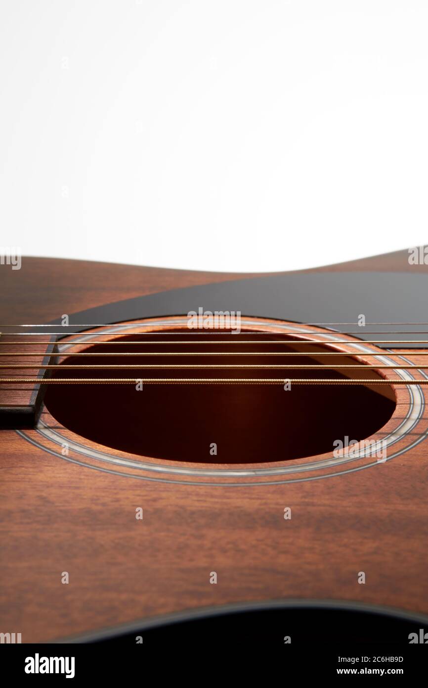 A close up of the top of a Fender acoustic guitar showing the sound hole and pickguard. Stock Photo