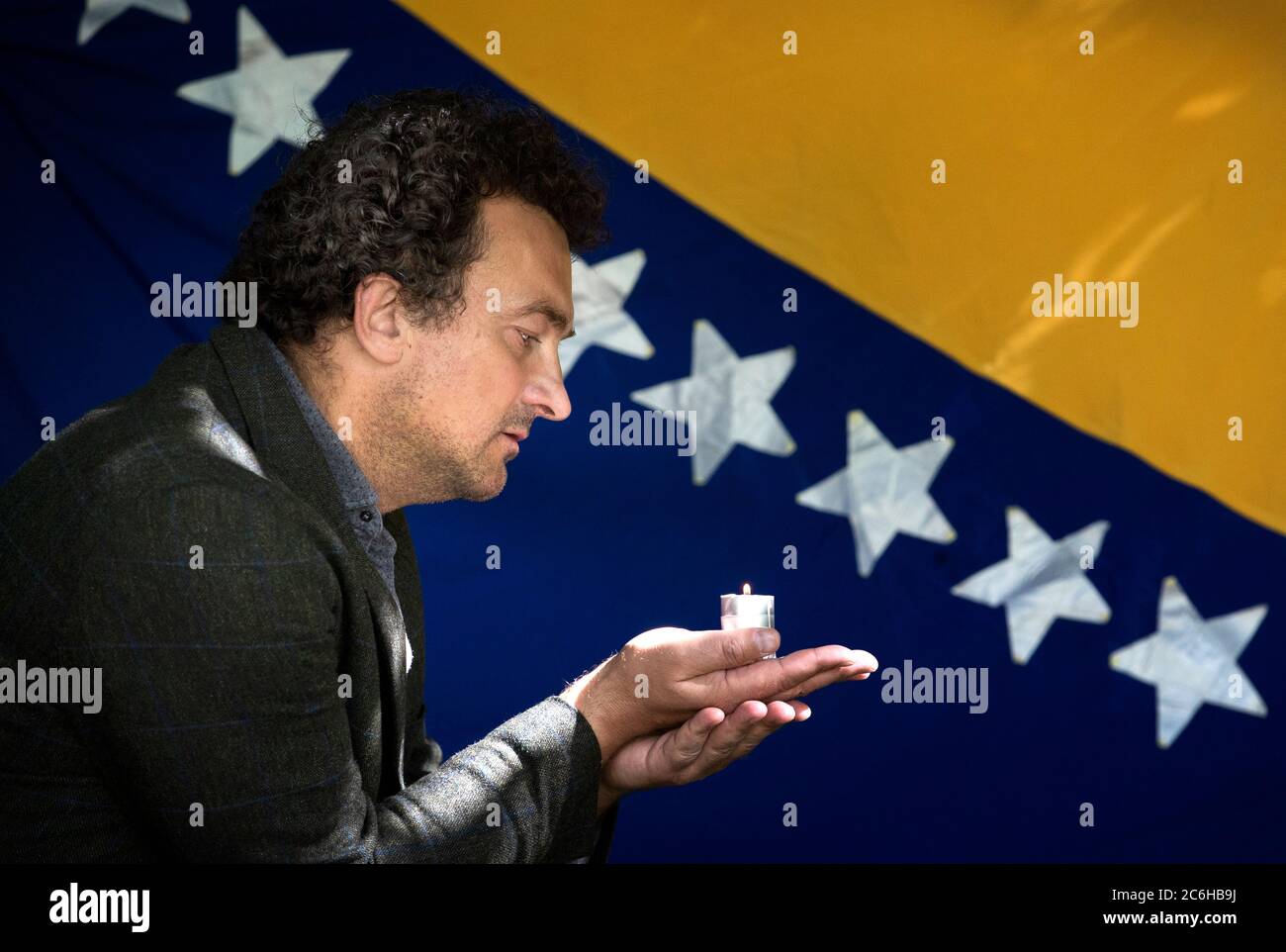 BAFTA award-winning film director Samir Mehanovic, who came to the UK as an immigrant from the Bosnian war in 1995 and now lives in Edinburgh, lights a candle to commemorate the 25th anniversary of the Srebrenica genocide. Stock Photo
