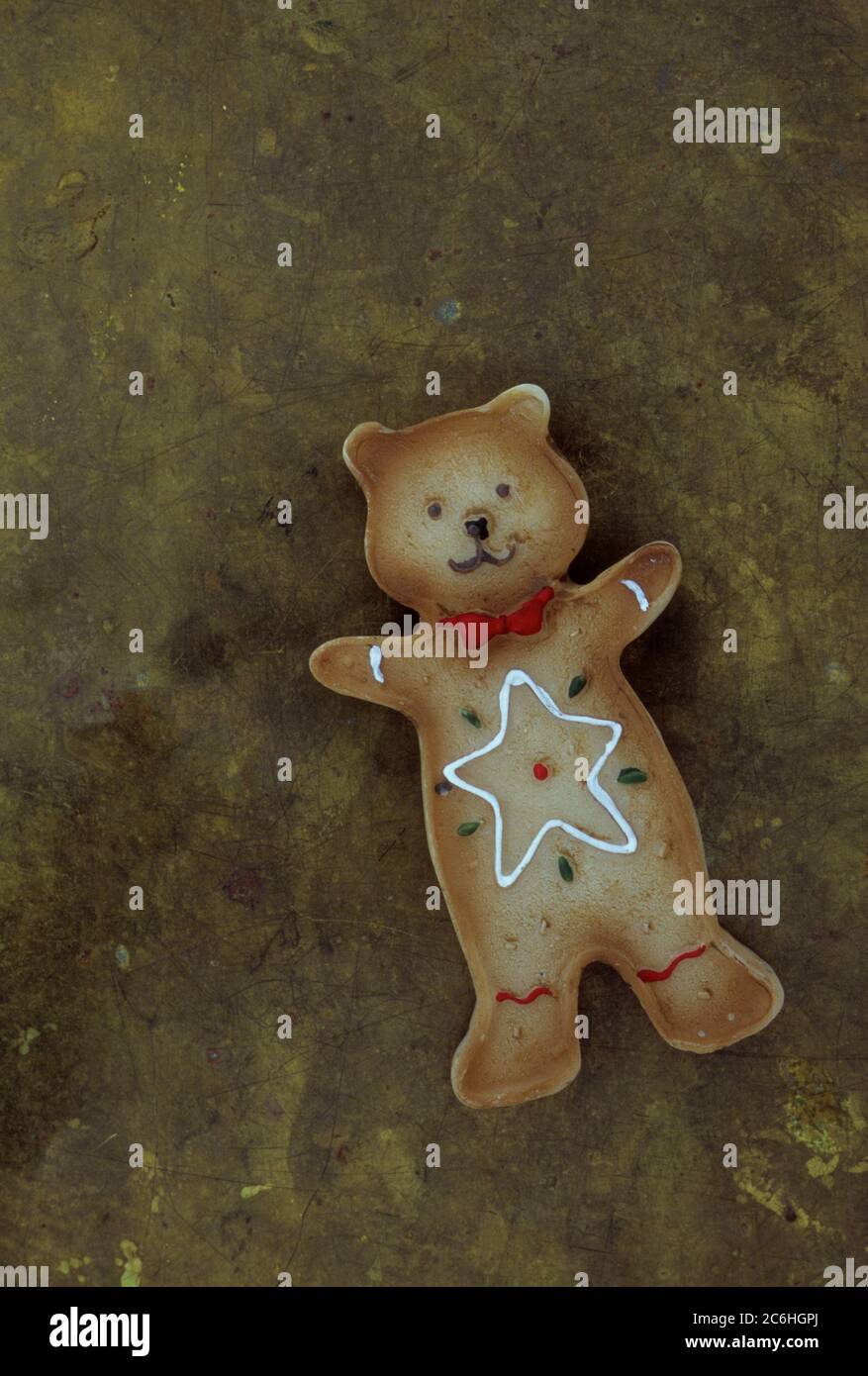 Gingerbread style teddy bear with star shape on its front lying on tarnished brass Stock Photo